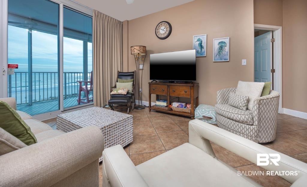 Image 4: Living area featuring tile patterned flooring and baseboards