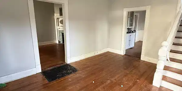 Image 3: Unfurnished dining area featuring dark wood-style floors, hanging lights, and ornamental molding