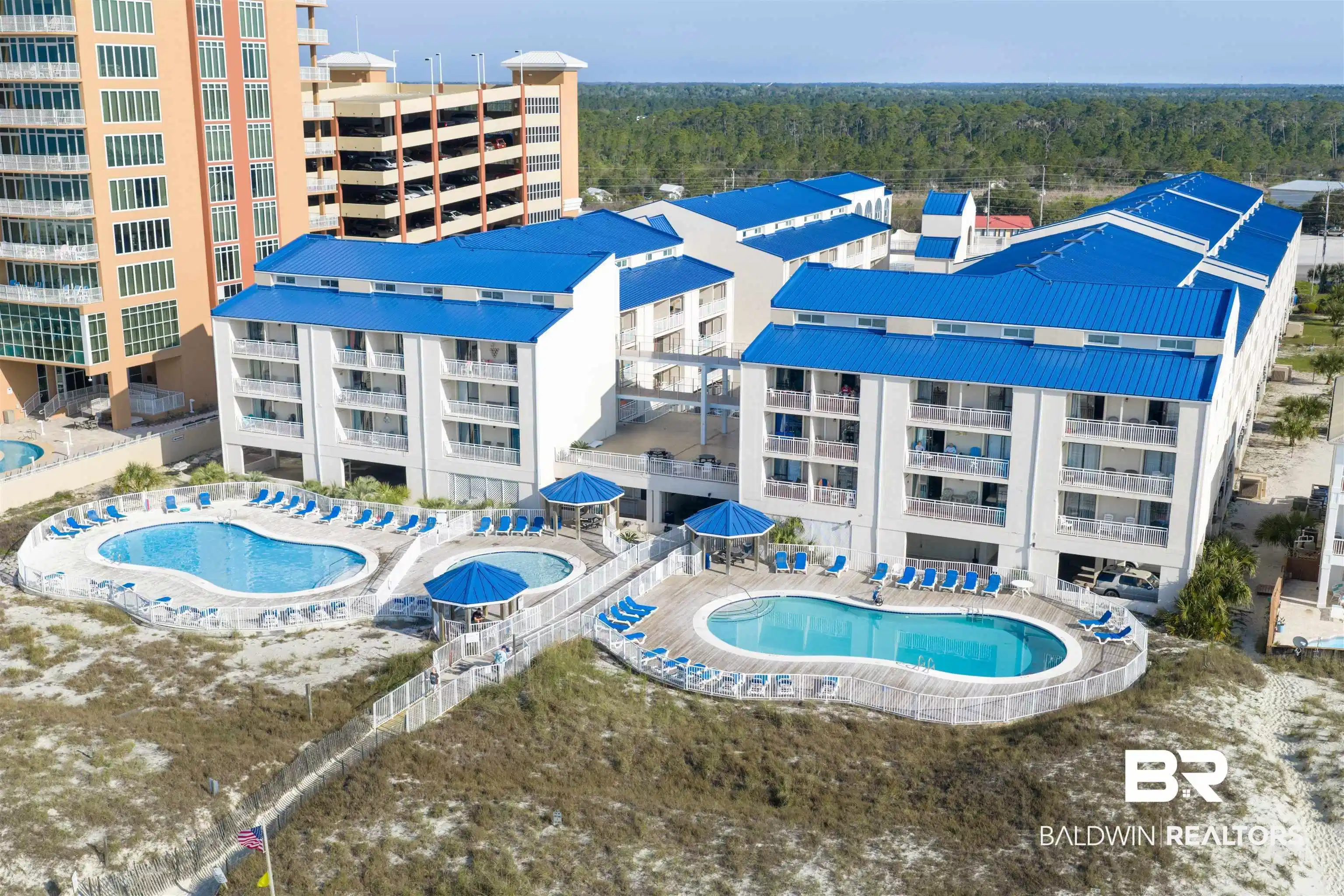 Image 1: Aerial view of a pool and apartment complex
