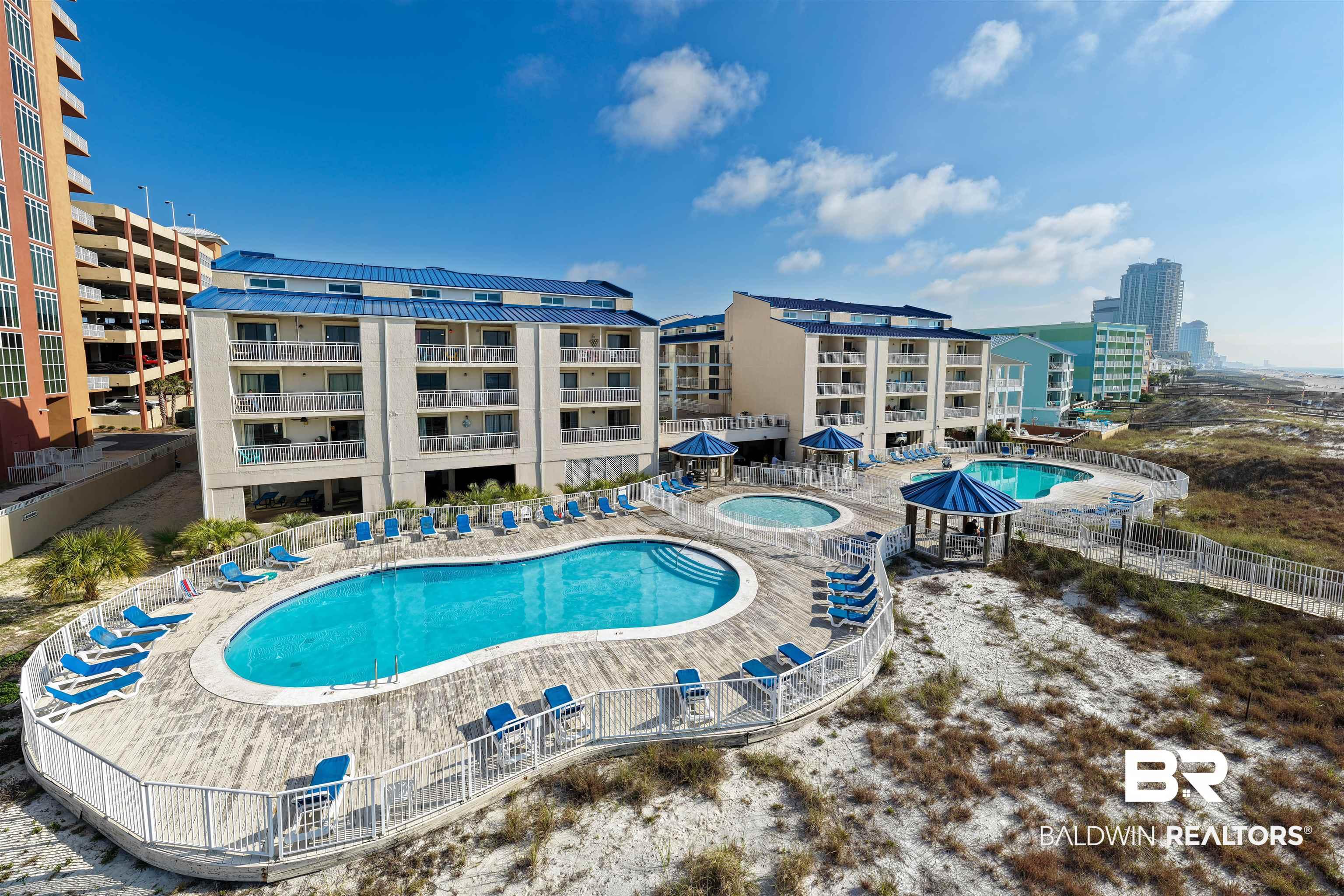 Image 4: Community pool with a community hot tub and a patio area