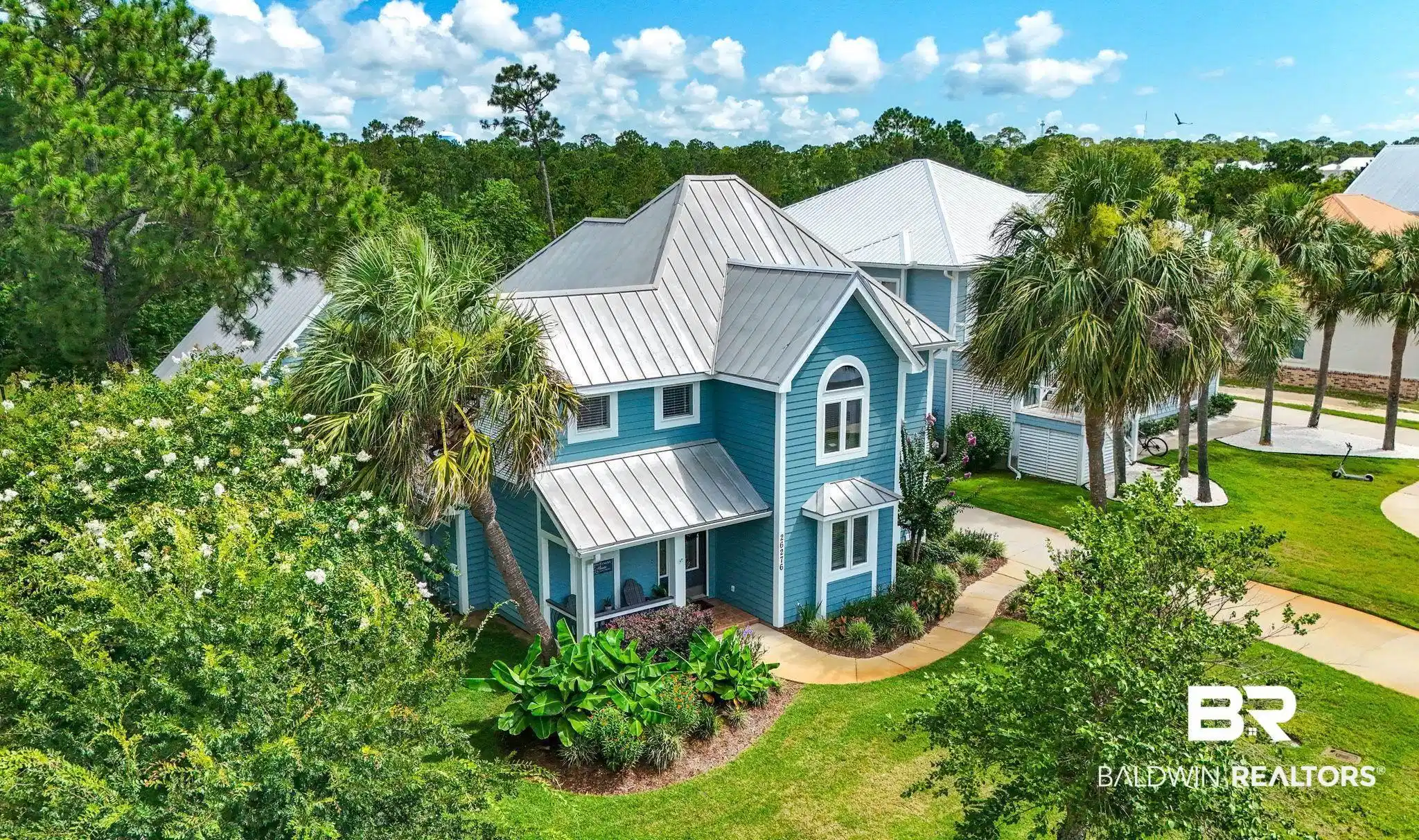 Image 1: View of front of house featuring a metal roof, a front lawn, and a standing seam roof