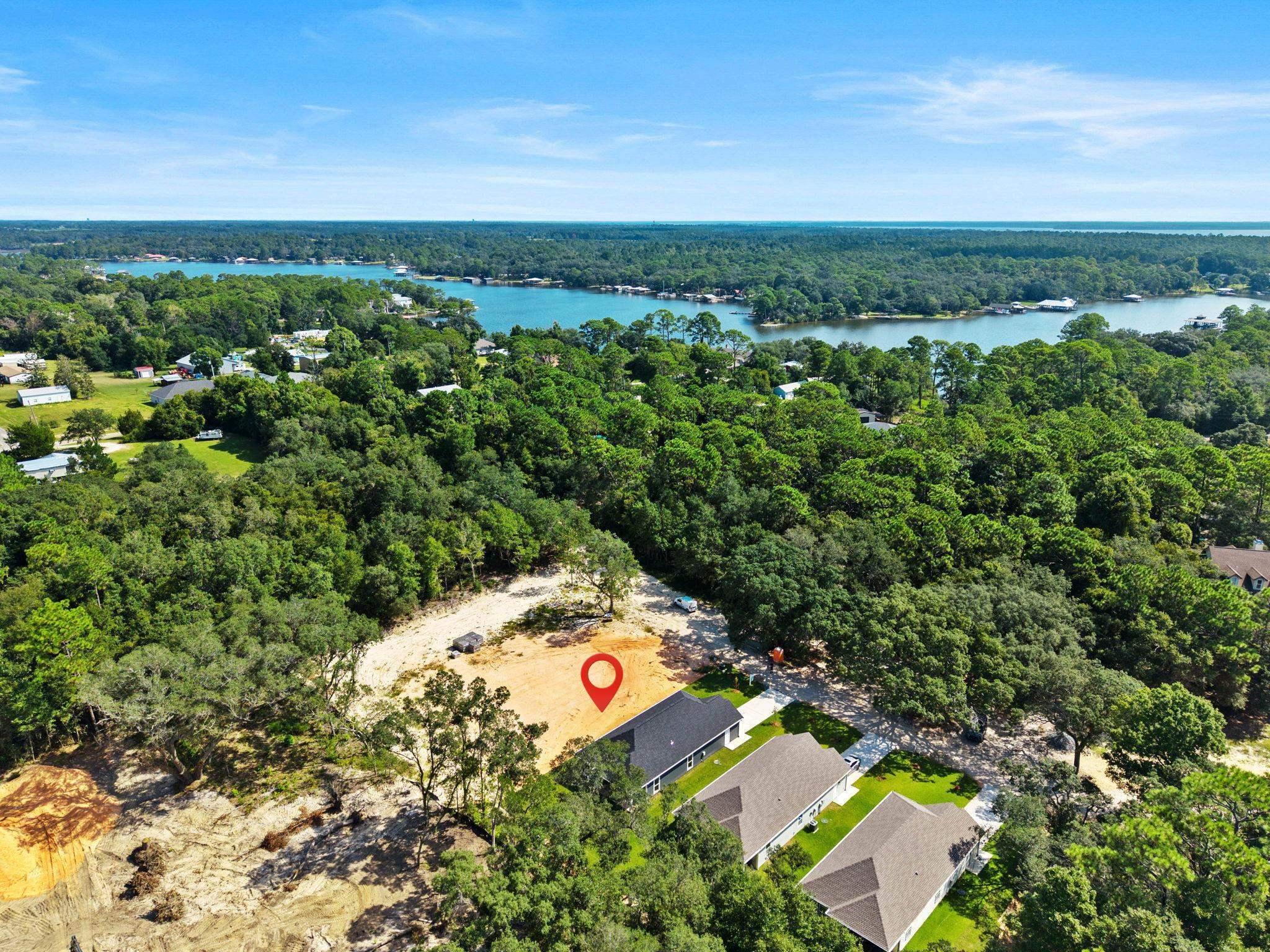 Image 1: Aerial overview of property's location with a forest and a large body of water