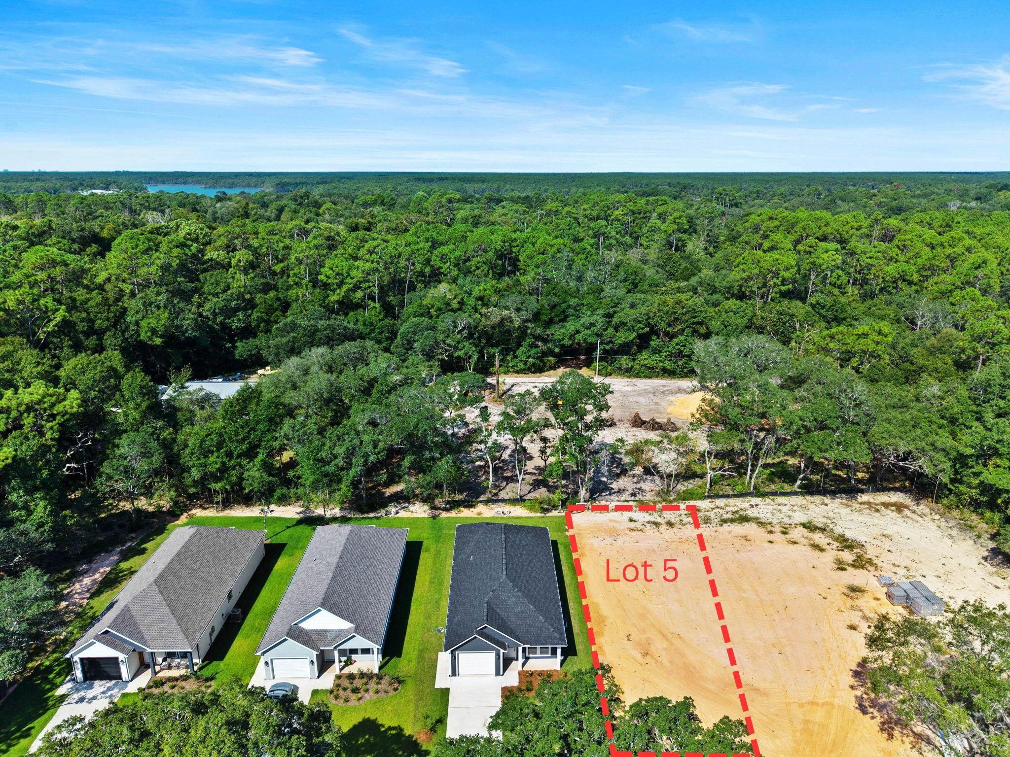 Image 2: Aerial overview of property's location featuring property parcel outlined and a forest