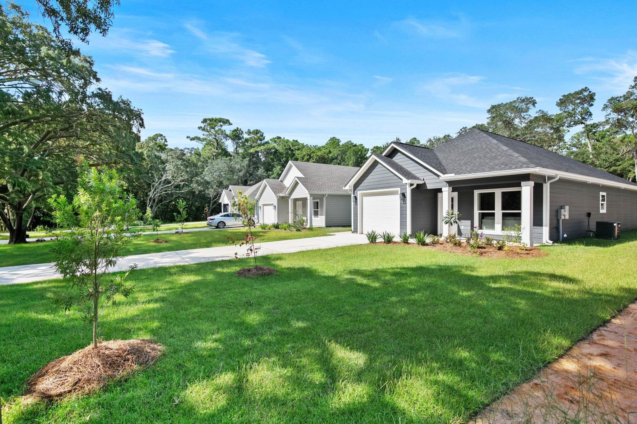 Image 3: Ranch-style home featuring concrete driveway, a front lawn, an attached garage, and a shingled roof