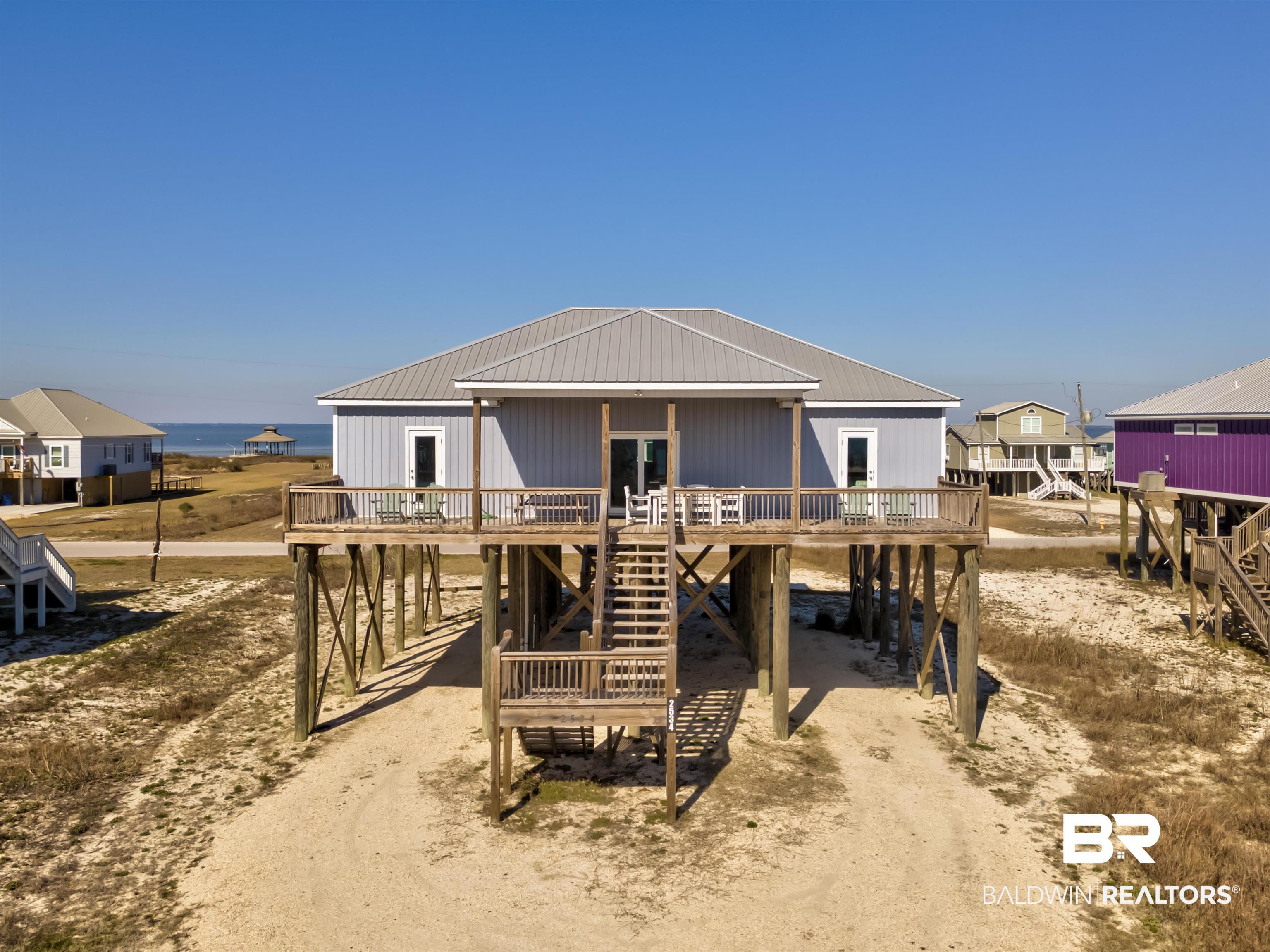 Image 1: View of front of property featuring a deck and stairs
