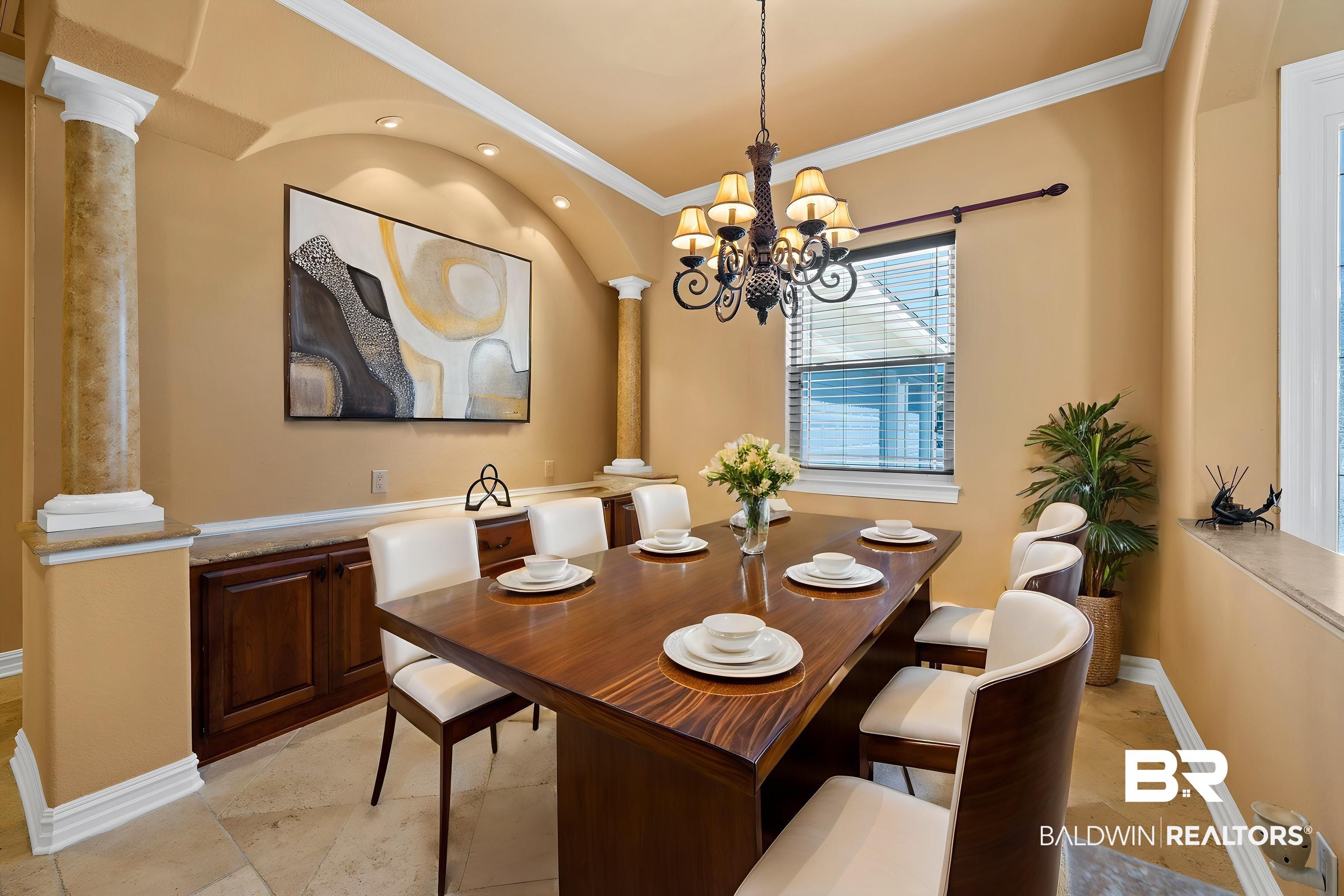Image 2: Formal dining area featuring a wood-finish table, tile flooring, and custom built-in cabinetry with a stone countertop