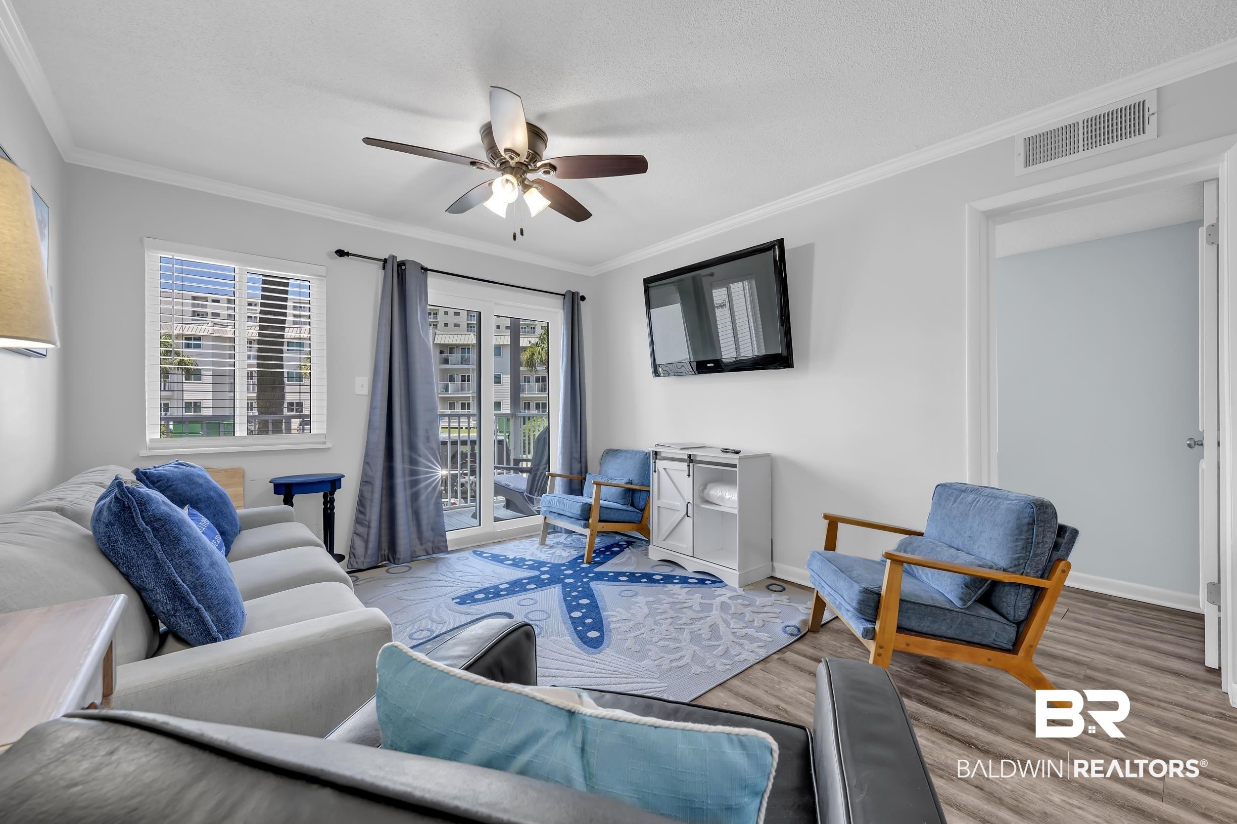 Image 4: Living area featuring wood-finish flooring, a ceiling fan, and crown molding