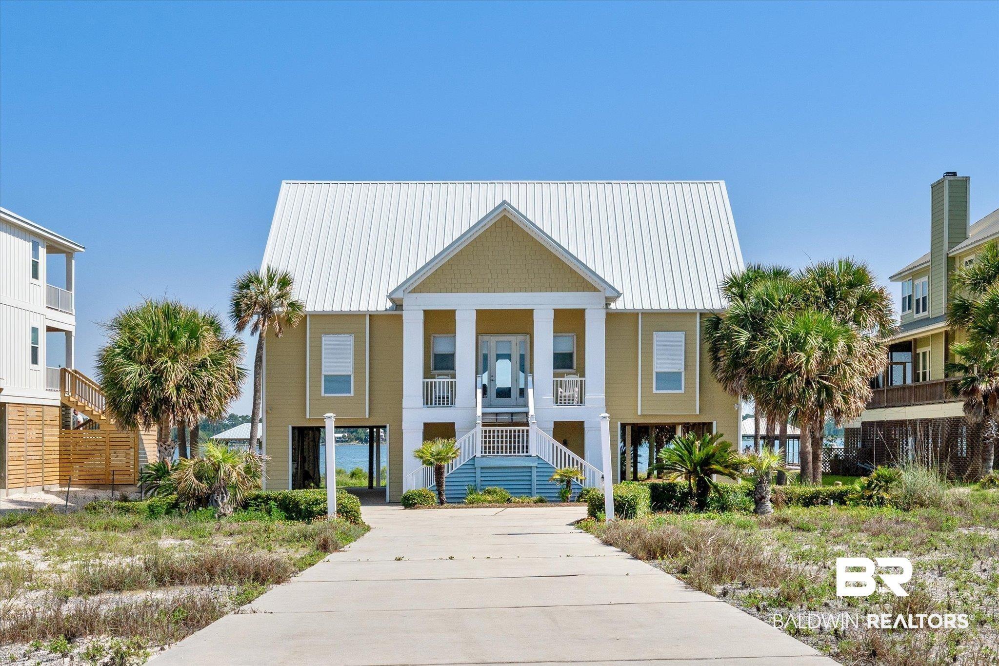 Image 2: View of front of house with stairs, a metal roof, and covered porch