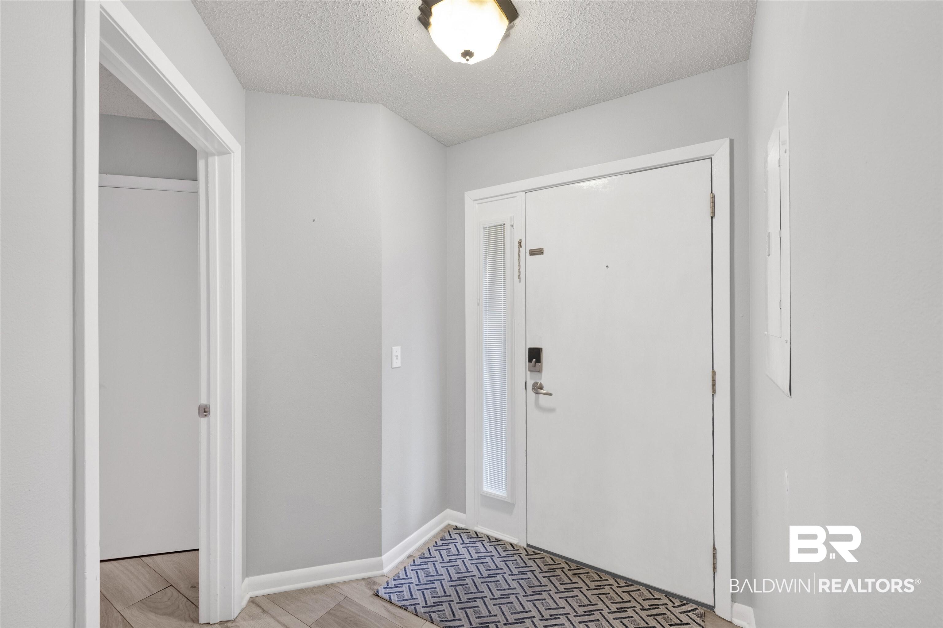 Image 2: Foyer entrance with a textured ceiling and wood finished floors