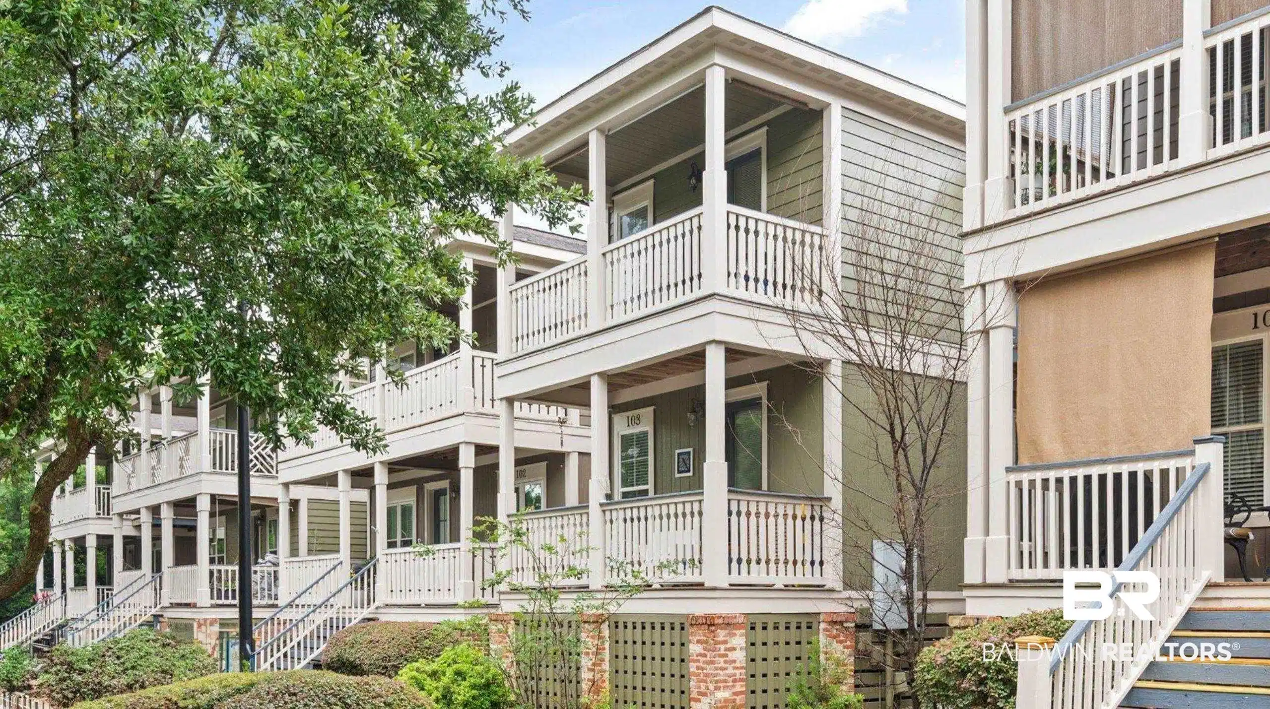 Image 1: View of front of home with stairway, a porch, and a balcony