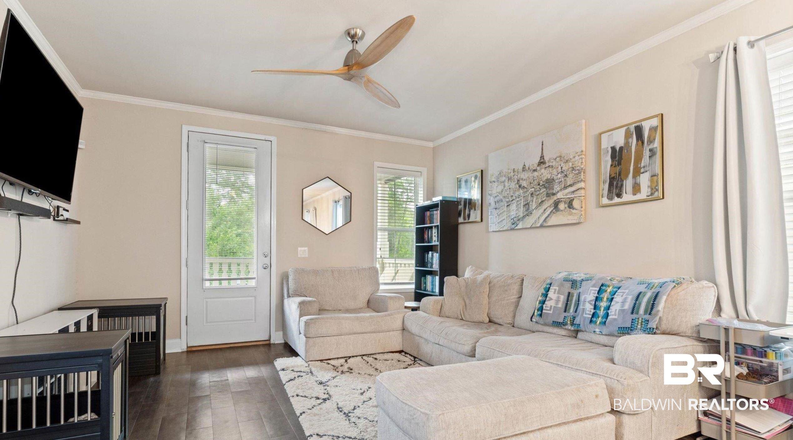 Image 2: Living room with a ceiling fan, dark wood finished floors, and crown molding