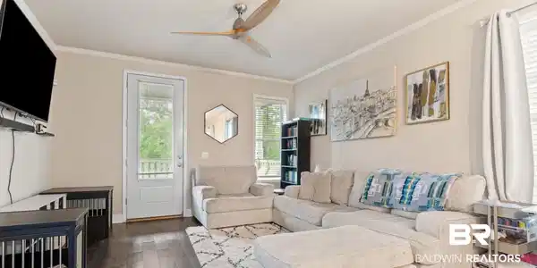 Image 2: Living room with a ceiling fan, dark wood finished floors, and crown molding