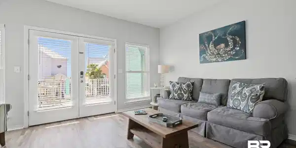 Image 4: Living room with LVP  wood  floors and french doors leading to deck