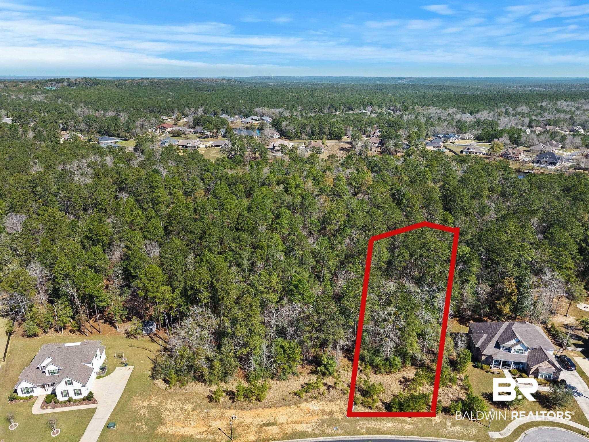 Image 2: Aerial view of property and surrounding area featuring a heavily wooded area and property parcel outlined