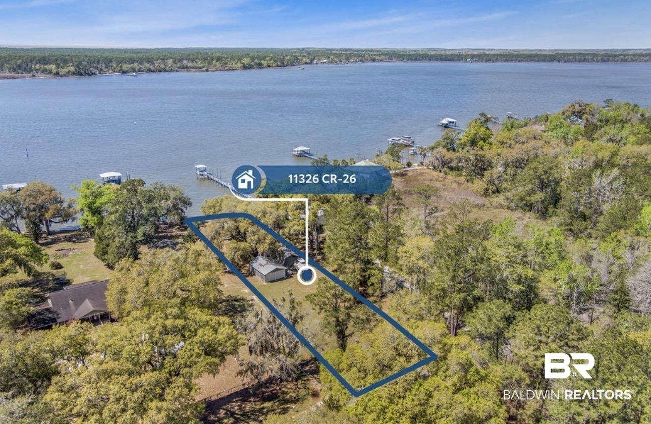 Image 3: Aerial view of property's location with property parcel outlined and a large body of water