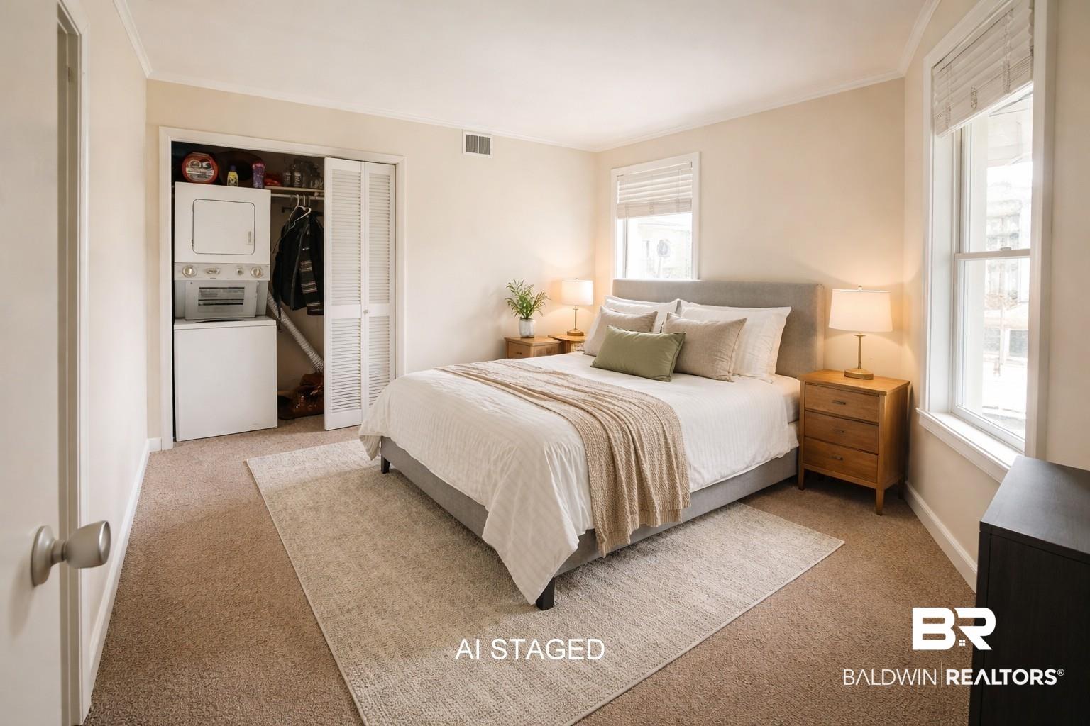 Image 4: Bedroom with stacked washing machine and dryer, a closet, carpet, and crown molding