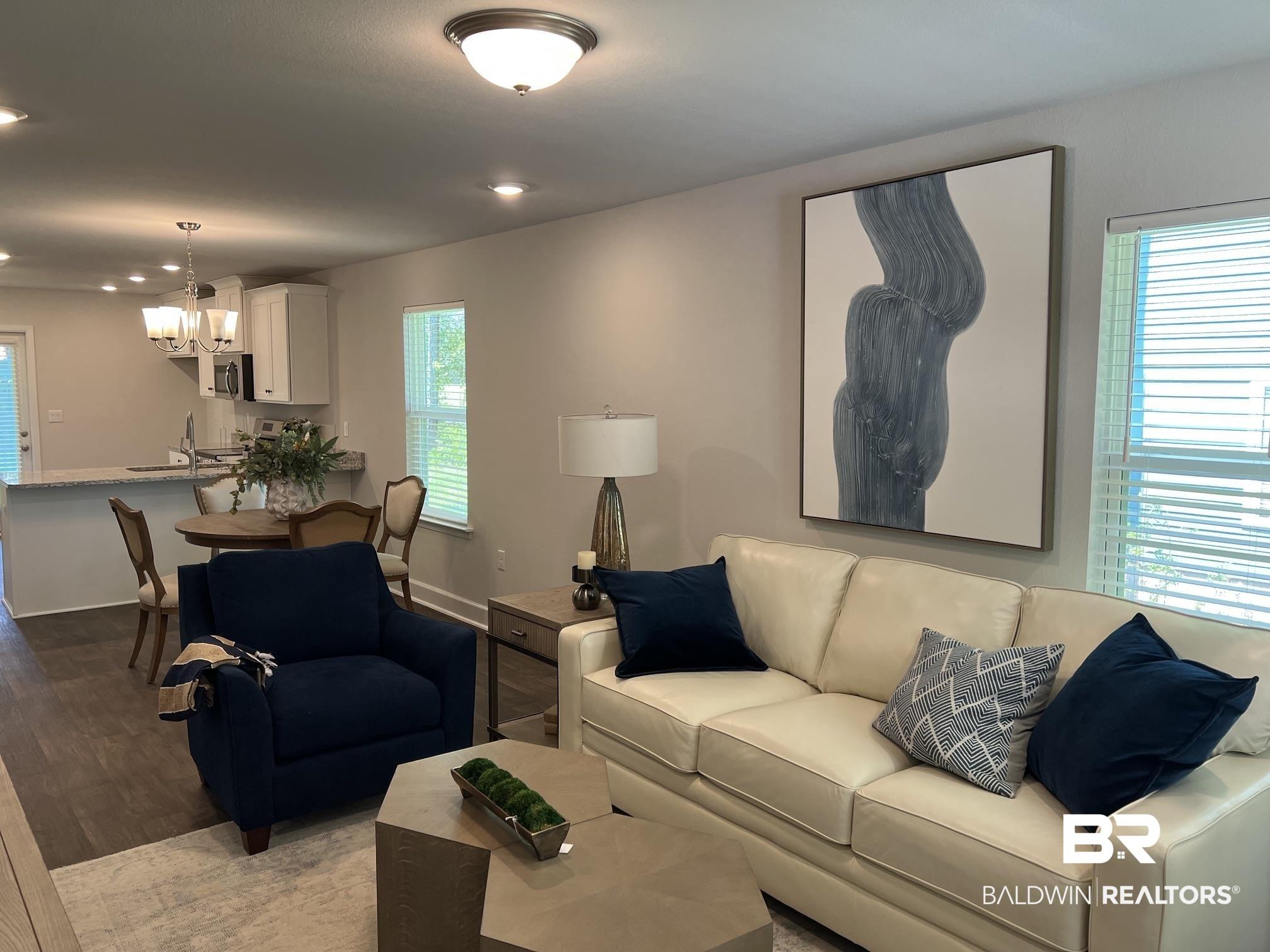 Image 3: Open-concept living area featuring wood-finish flooring, recessed lighting, and a neutral color palette