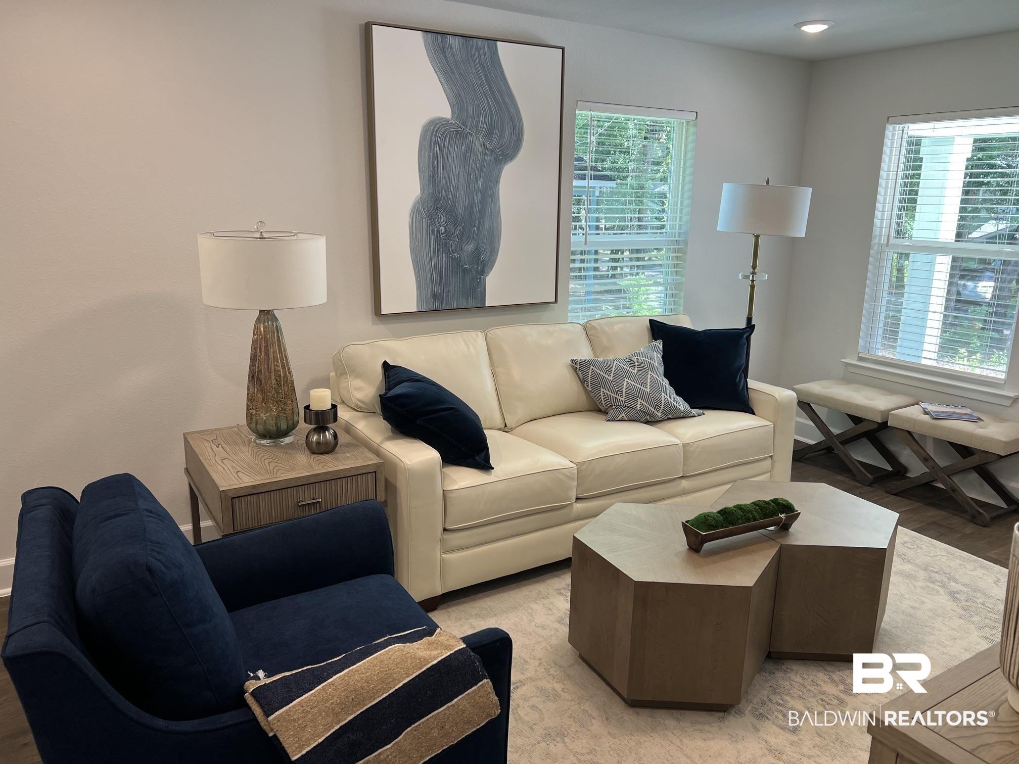 Image 4: Living area featuring light-toned walls and wood-finish flooring