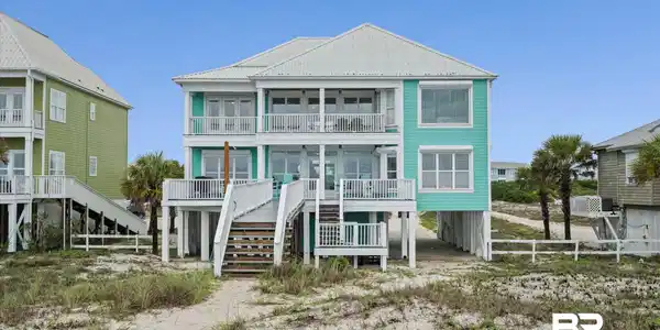 Image 4: Three-story coastal residence featuring a turquoise exterior and multiple private balconies
