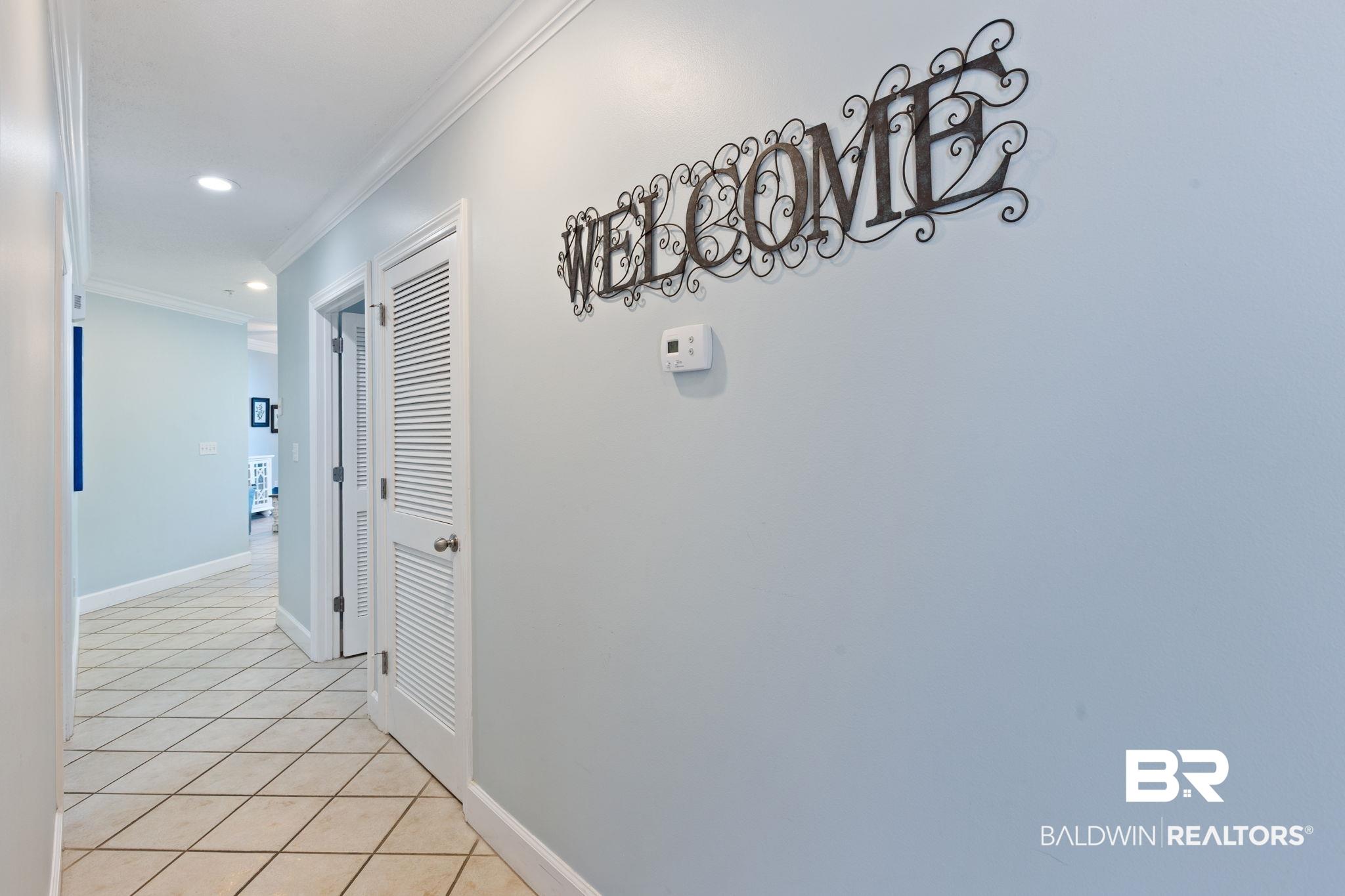 Image 3: Hallway with light tile patterned floors, ornamental molding, and recessed lighting