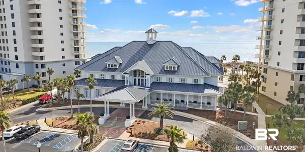 Image 4: View of building exterior featuring uncovered parking and a water view