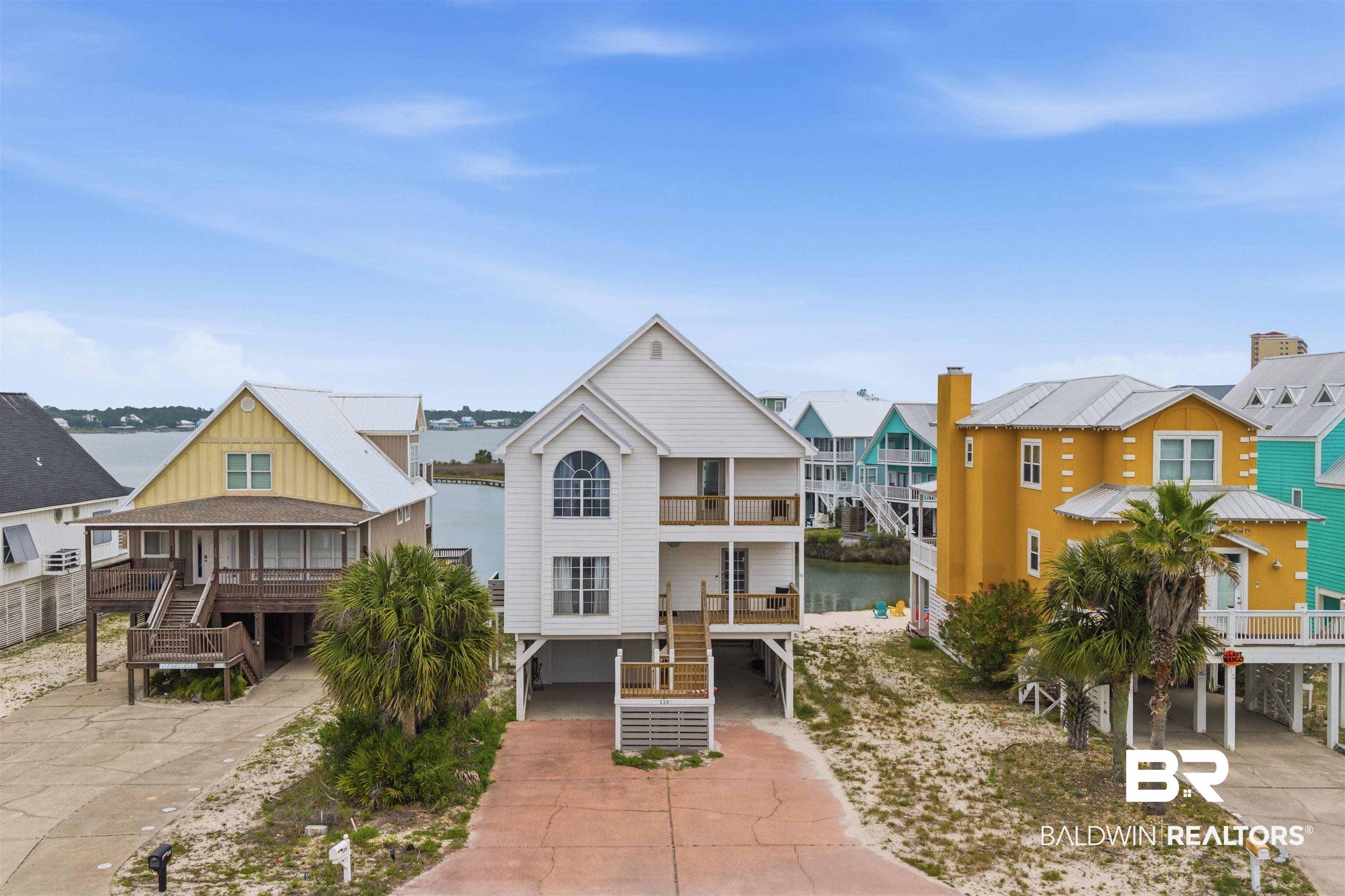 Image 1: Two-story coastal residence featuring multiple balconies and a prominent arched window