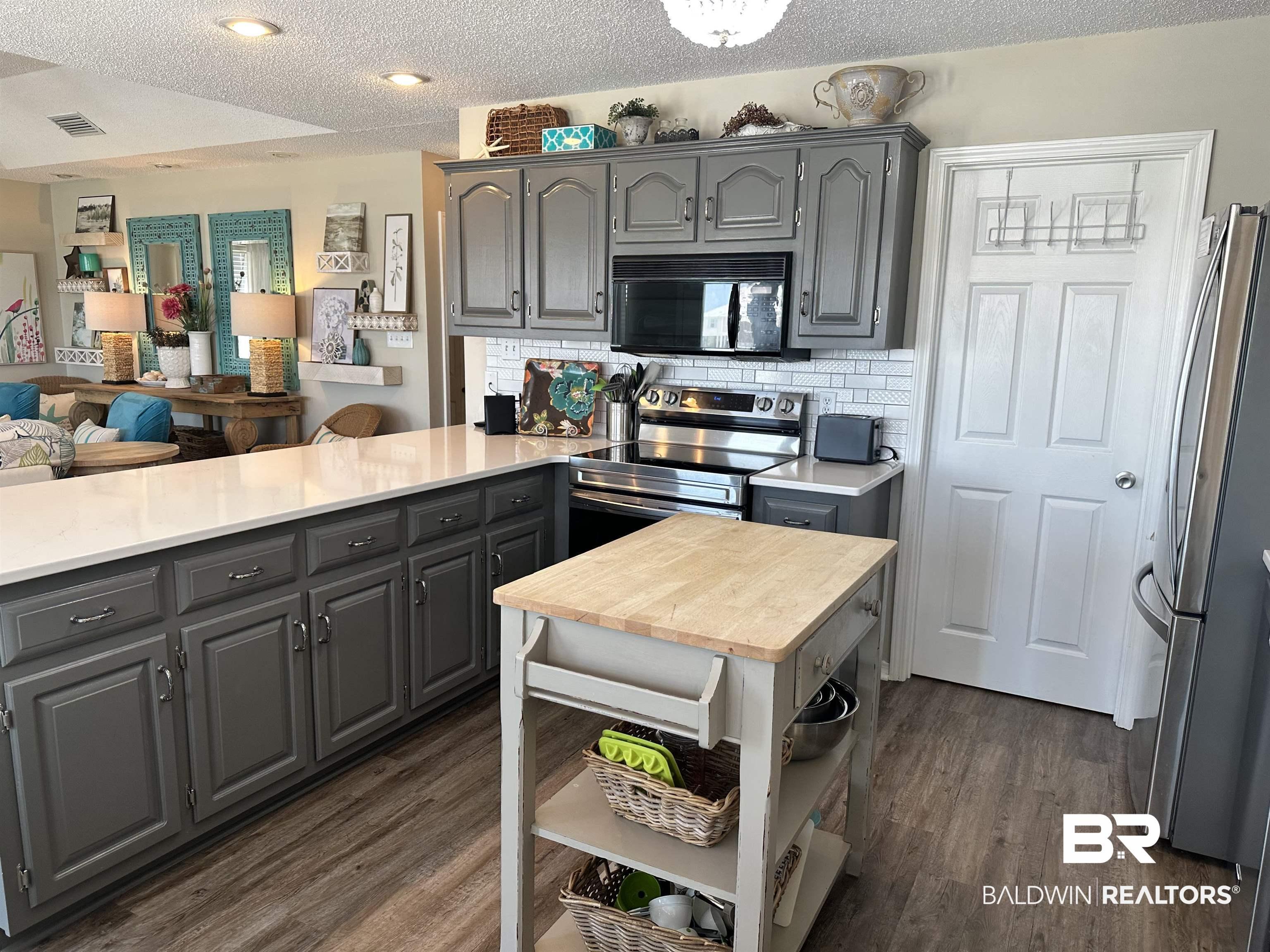Image 4: Kitchen featuring grey cabinetry, white subway tile backsplash, and wood-finish flooring