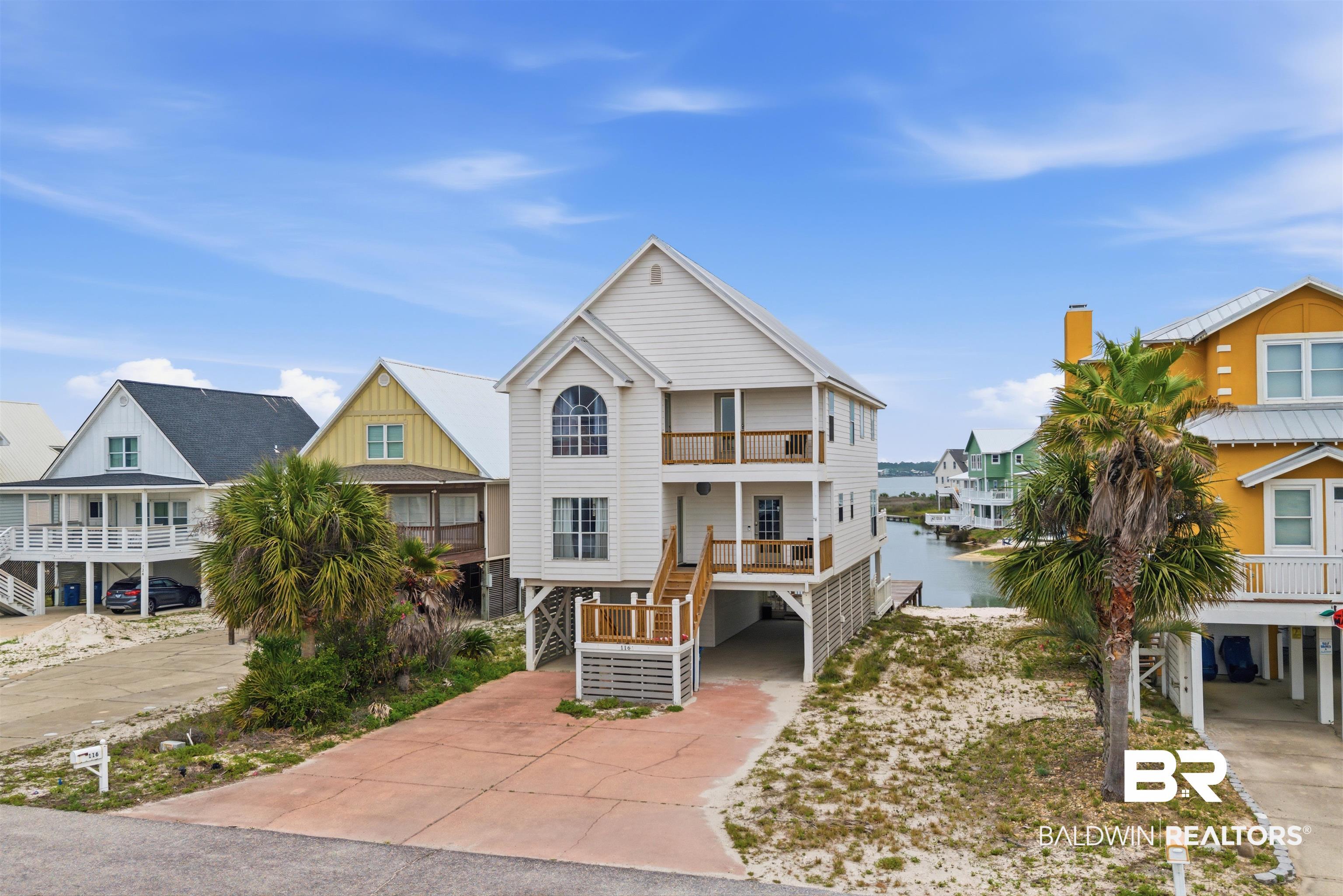 Image 2: Three-story coastal residence featuring a white exterior with multiple balconies