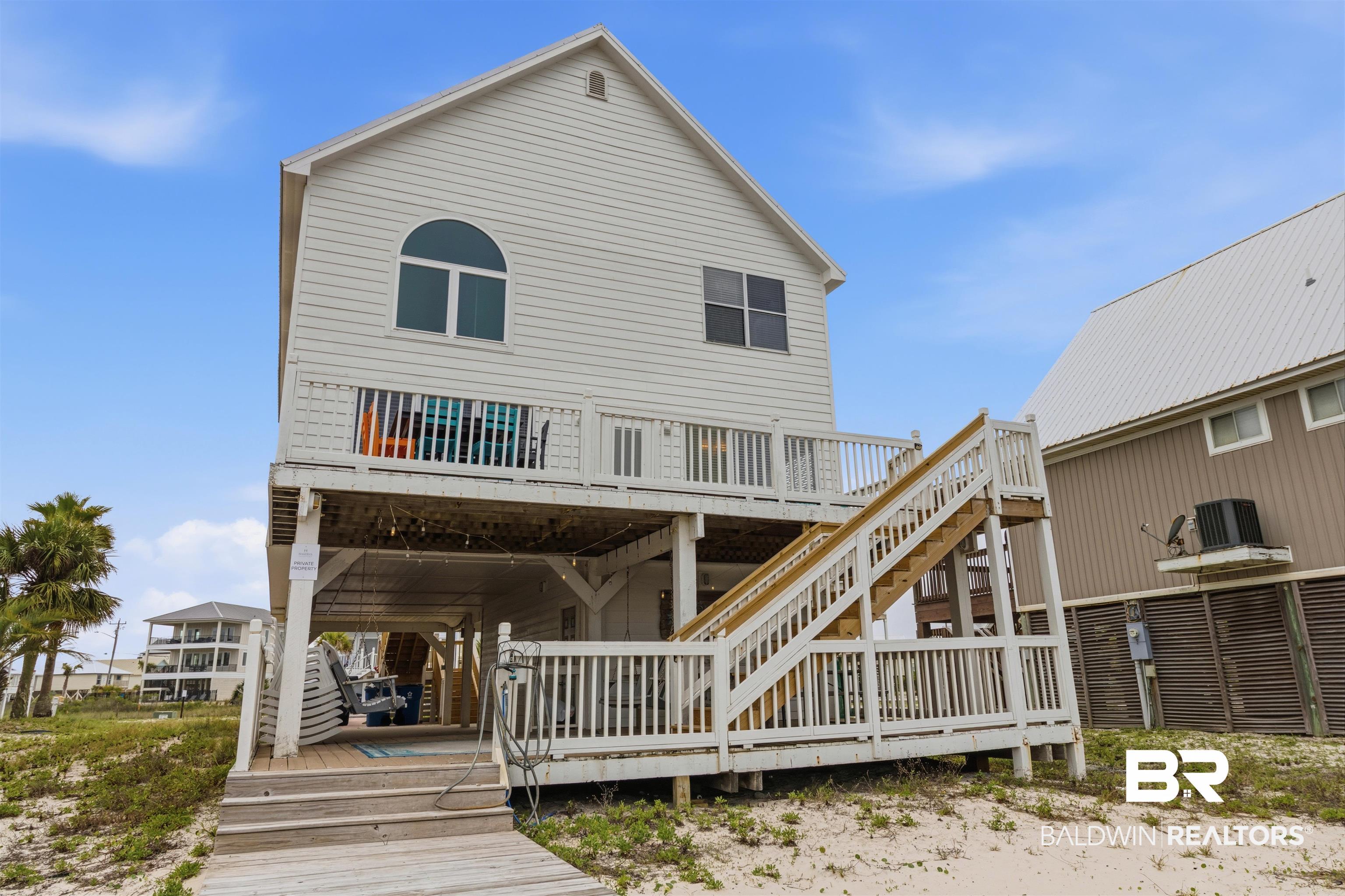 Image 3: Elevated coastal residence featuring white siding and a multi-level deck
