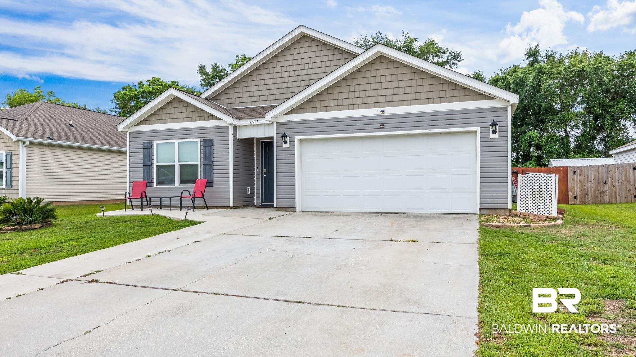 Image 2: Single-story residence featuring gray siding with complementary shake accents and white trim