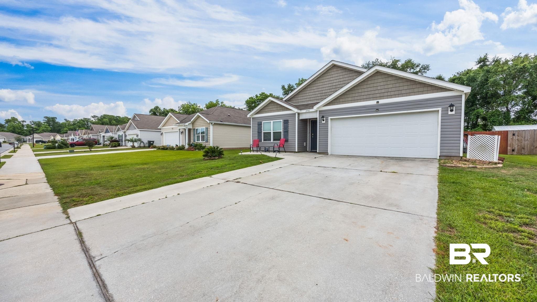 Image 3: Siding exterior with a two-car garage and concrete driveway