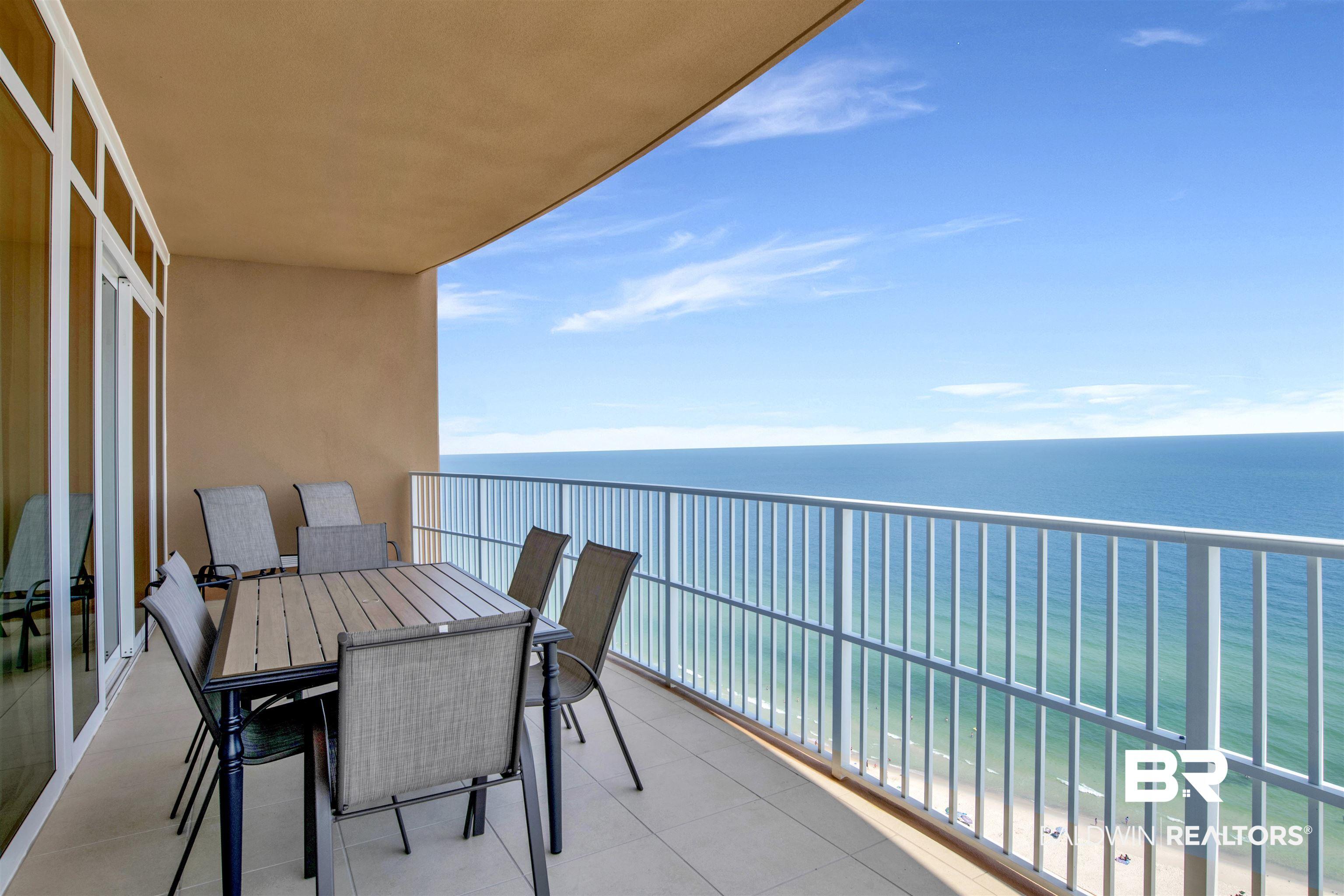 Image 2: Expansive outdoor balcony featuring a white railing, tile flooring, and a broad ocean backdrop