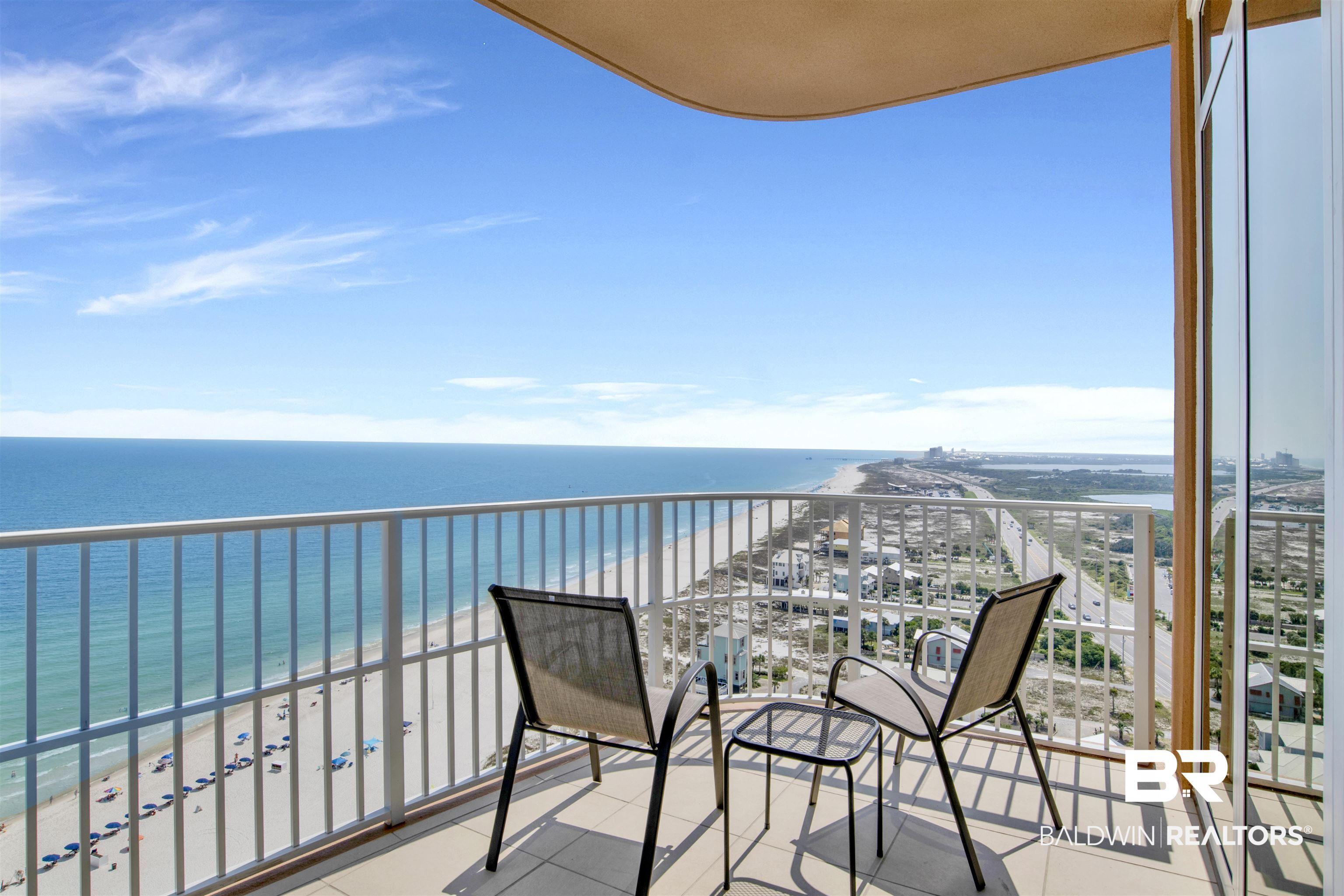 Image 3: Expansive balcony featuring a white railing, a beige curved ceiling, and light-colored tile flooring