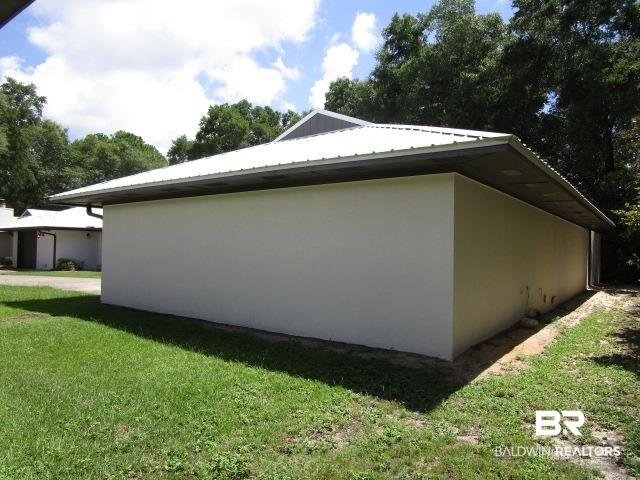 Image 3: View of side of home with stucco siding and a yard