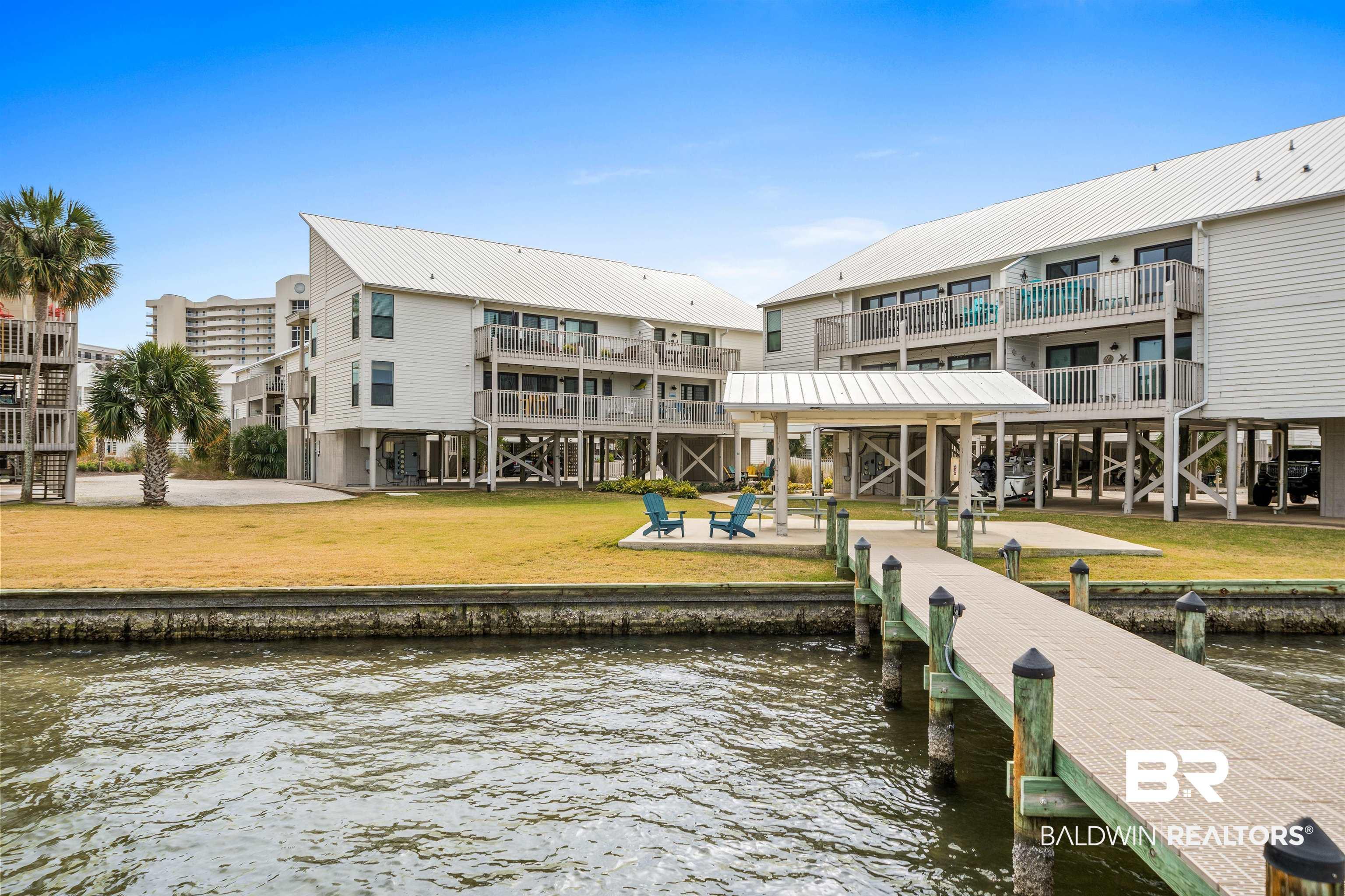Image 3: Dock featuring a water view and a yard