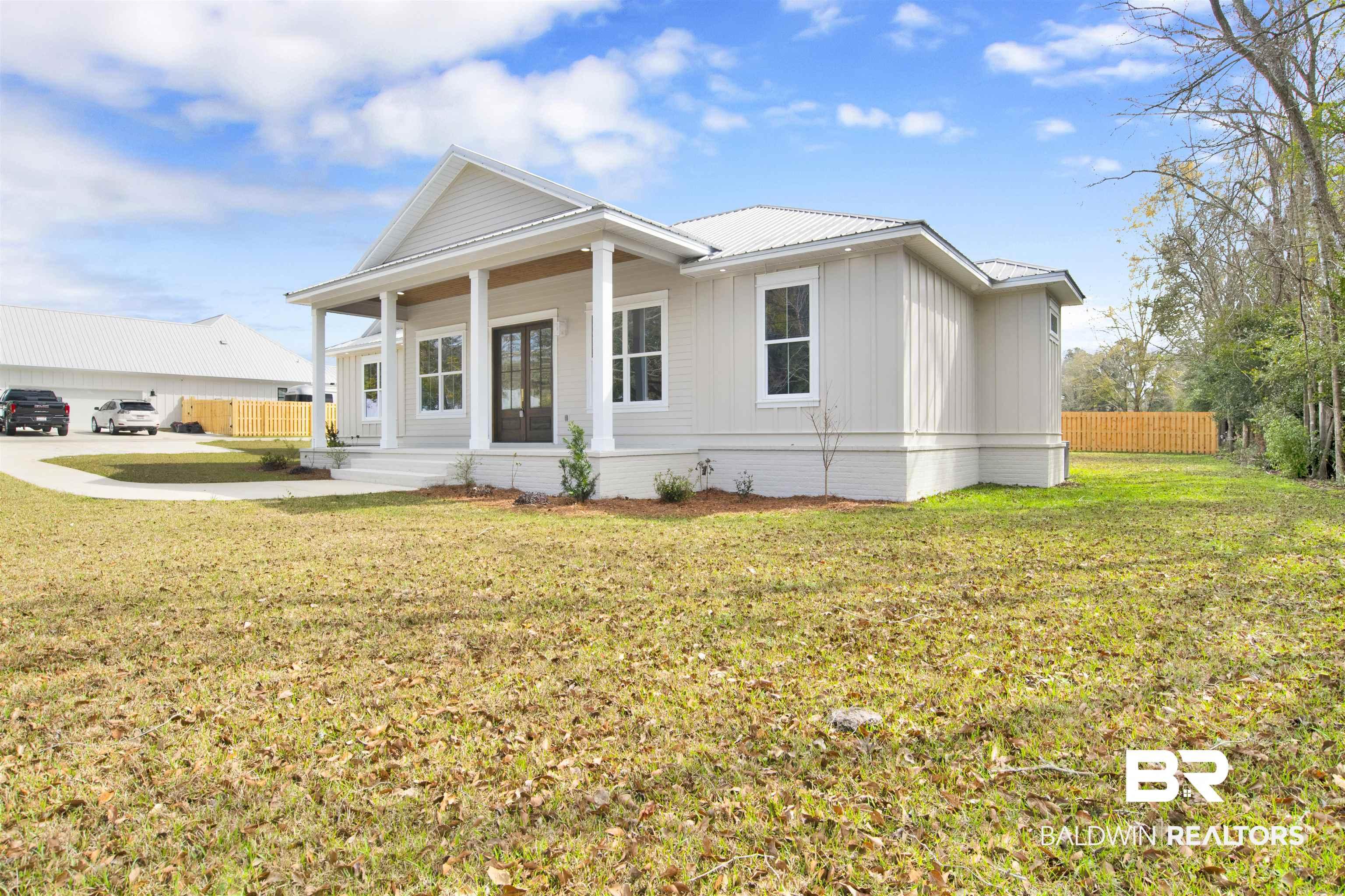 Image 2: View of front of property with a porch, a metal roof, and board and batten siding