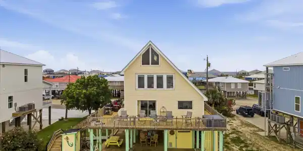 Image 2: Elevated coastal residence featuring a prominent A-frame architectural style and a spacious outdoor deck
