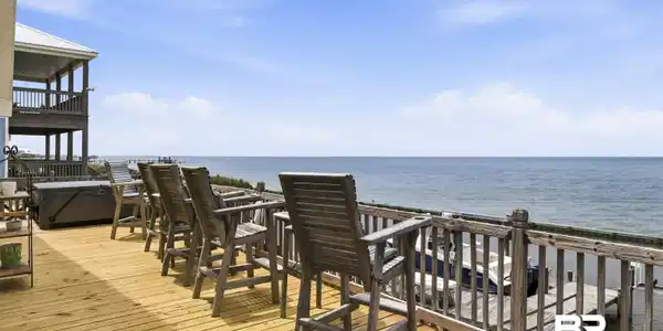Image 3: Expansive waterfront deck featuring natural wood flooring and a wooden railing system