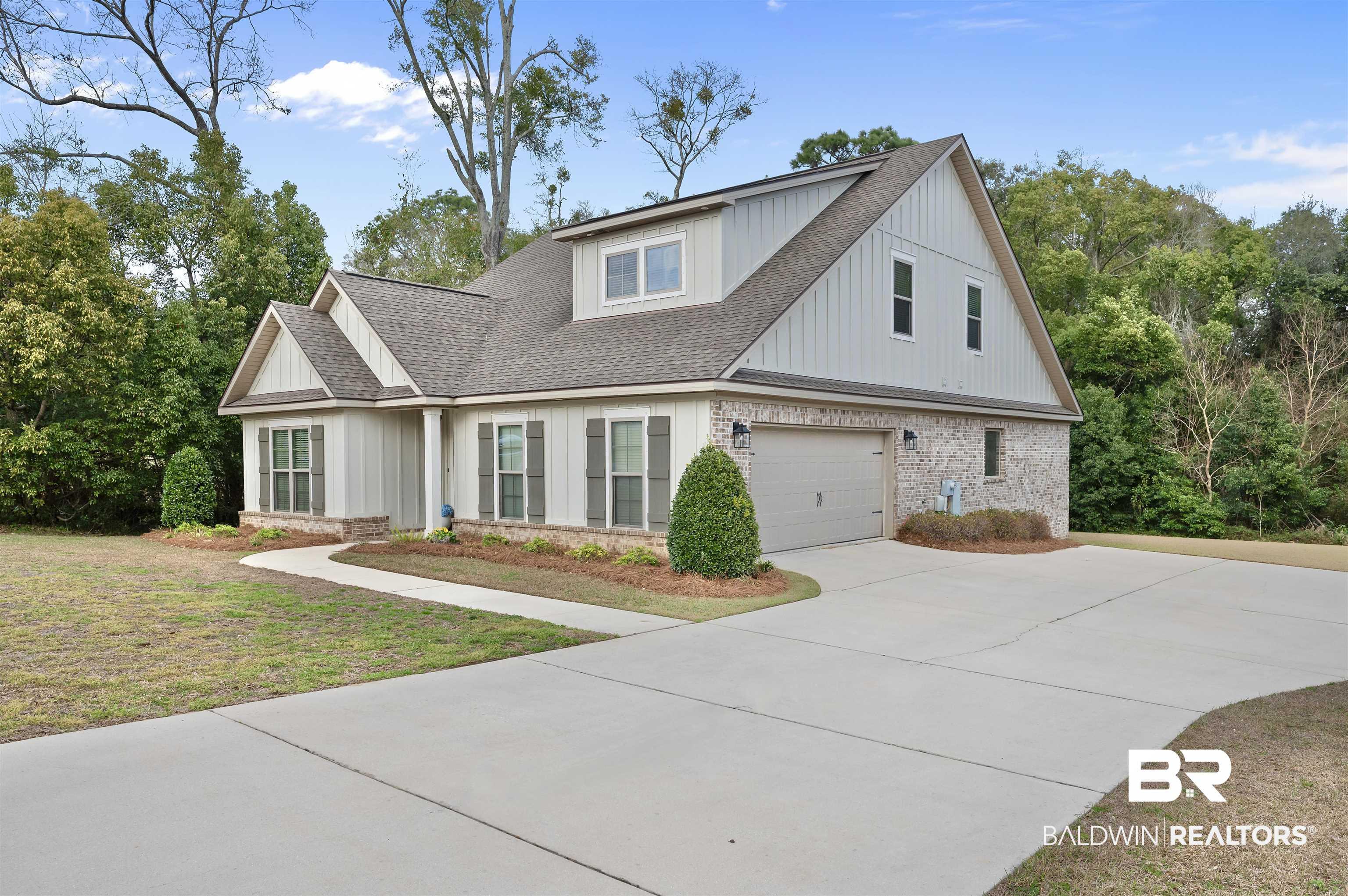 Image 2: Modern farmhouse style home with brick siding, roof with shingles, driveway, an attached garage, and board and batten siding