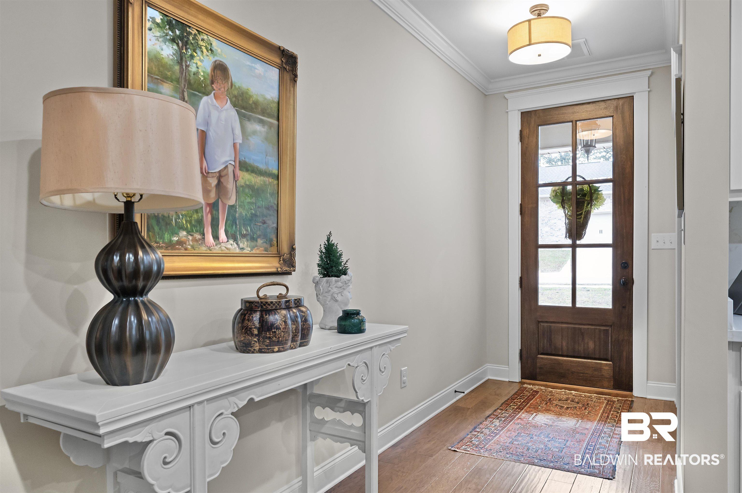 Image 4: Entrance foyer with crown molding and light wood finished floors