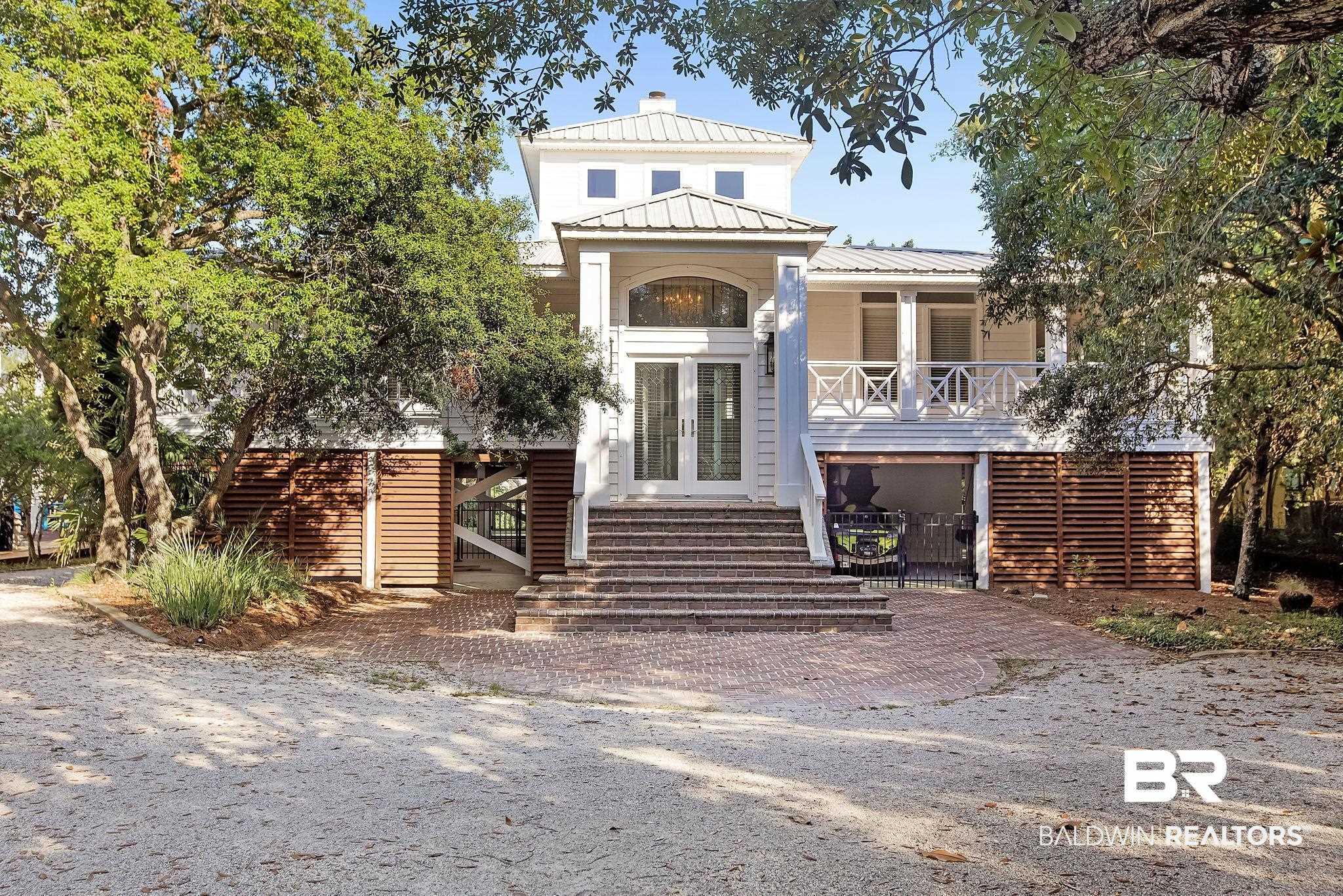 Image 1: View of front facade with stairway, french doors, and a metal roof