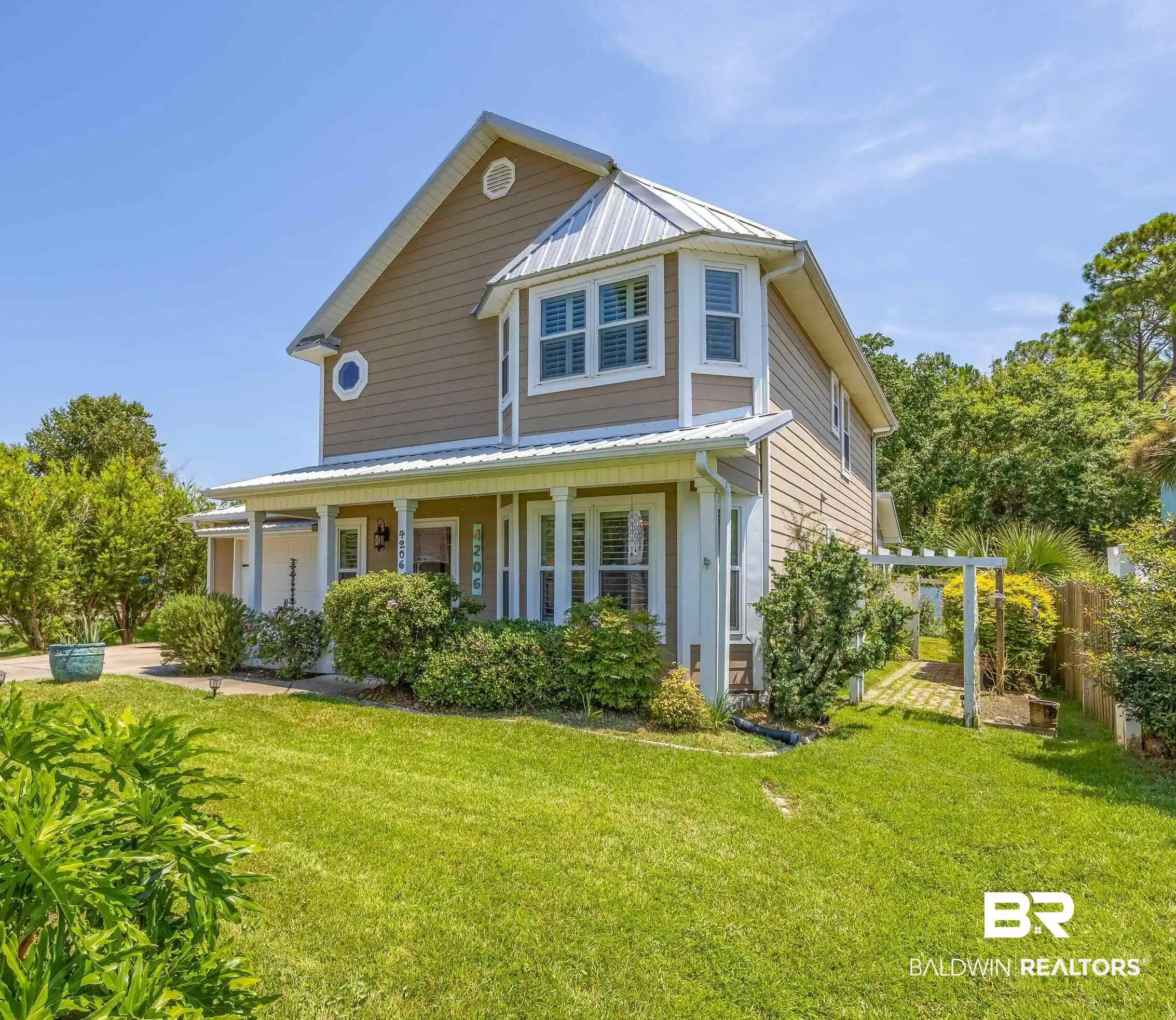 Image 1: View of front of house featuring a metal roof, a front yard, and a porch