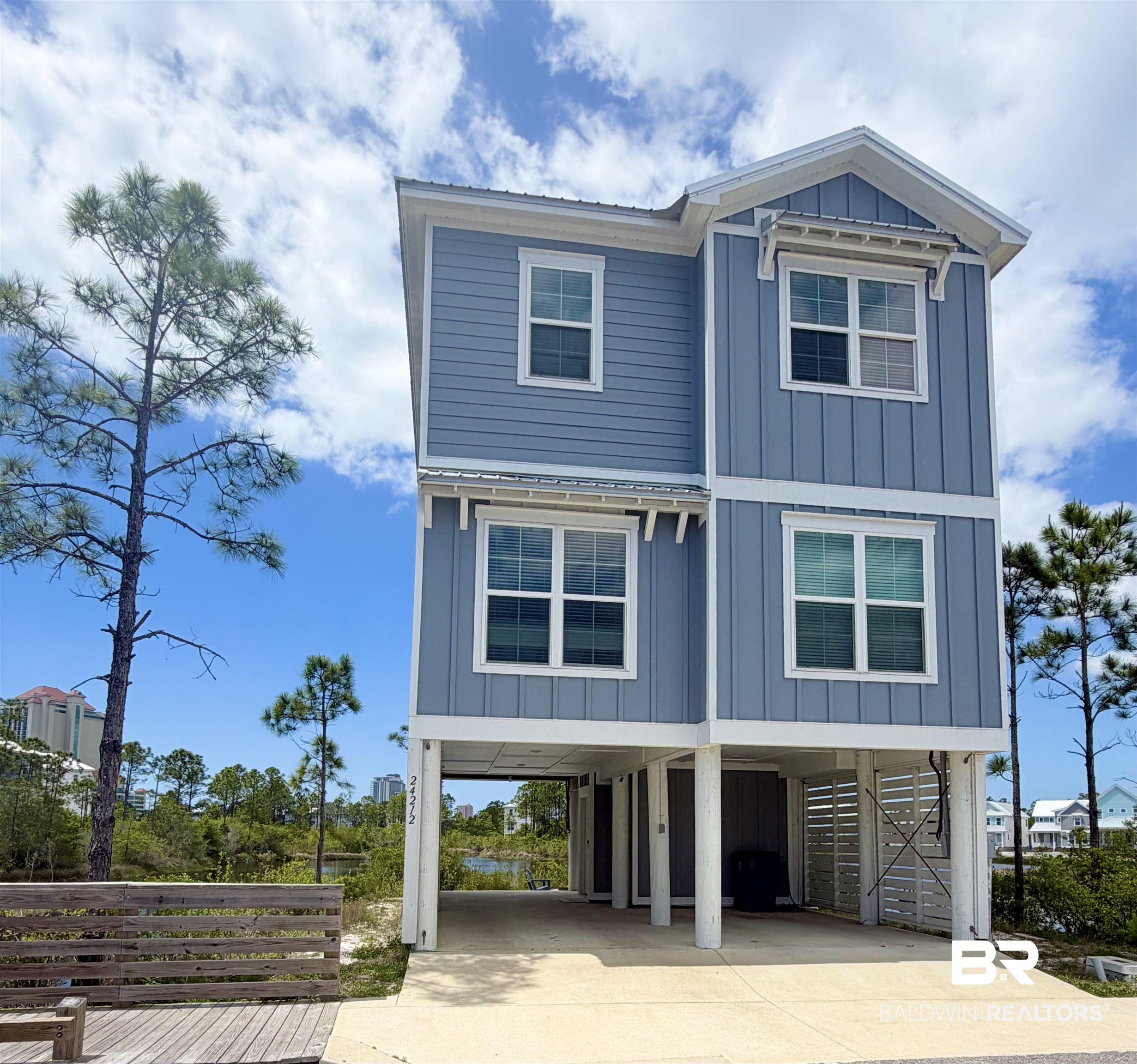 Image 2: Two-story coastal-style residence featuring blue siding and white trim