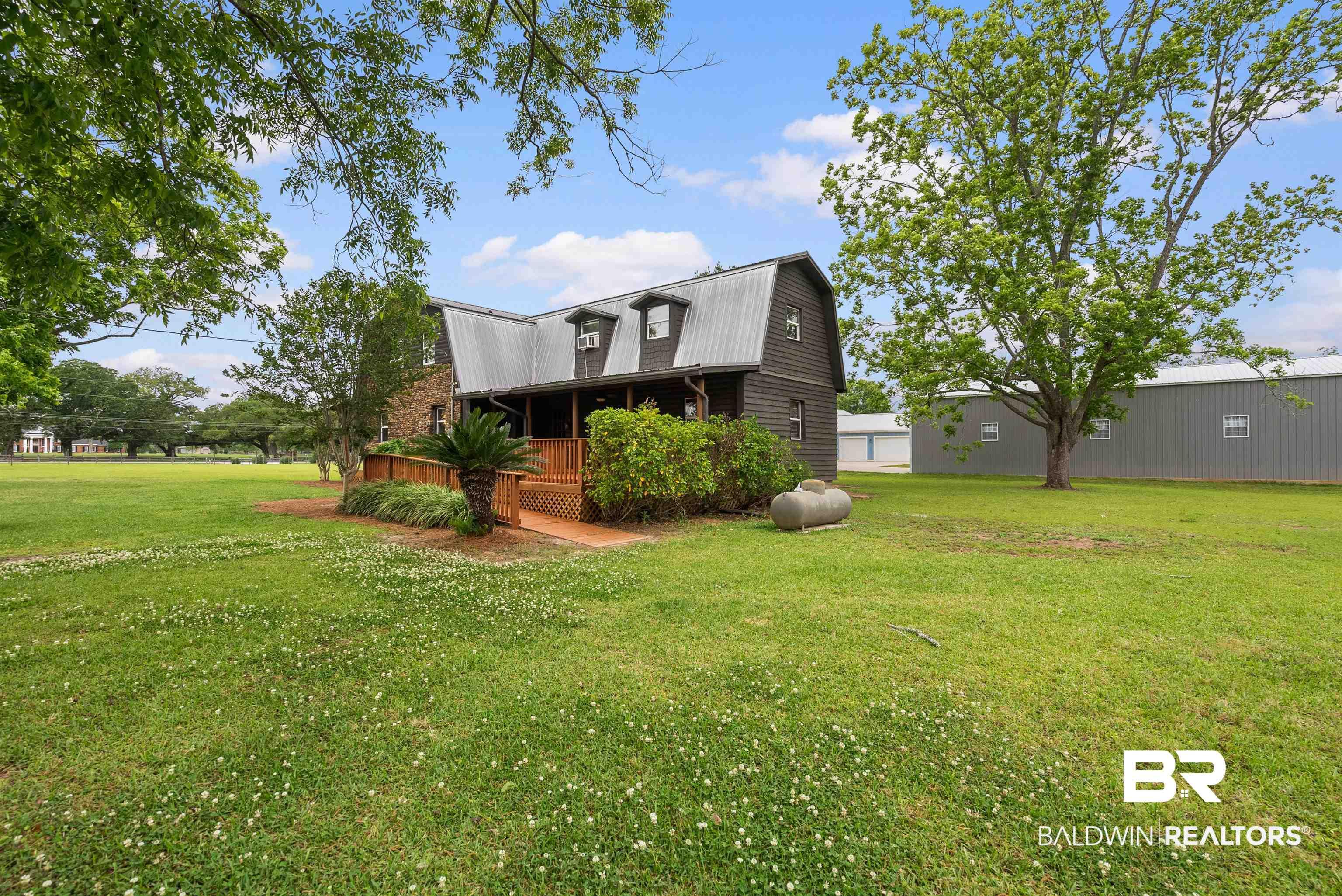 Image 1: Barn-style residence featuring a metal roof and dormer windows