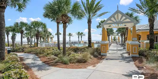 Image 4: Landscaped walkway leading to a gated entry arbor