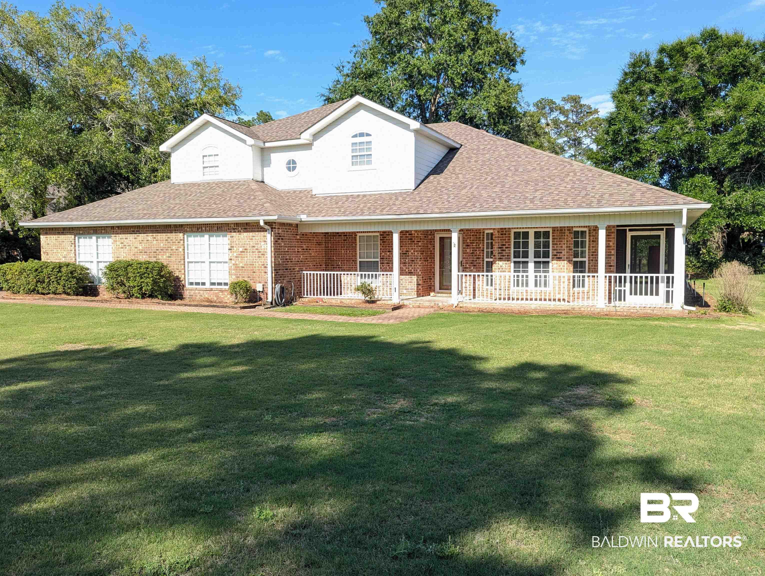 Image 1: Brick and siding exterior with a covered front porch featuring white railings
