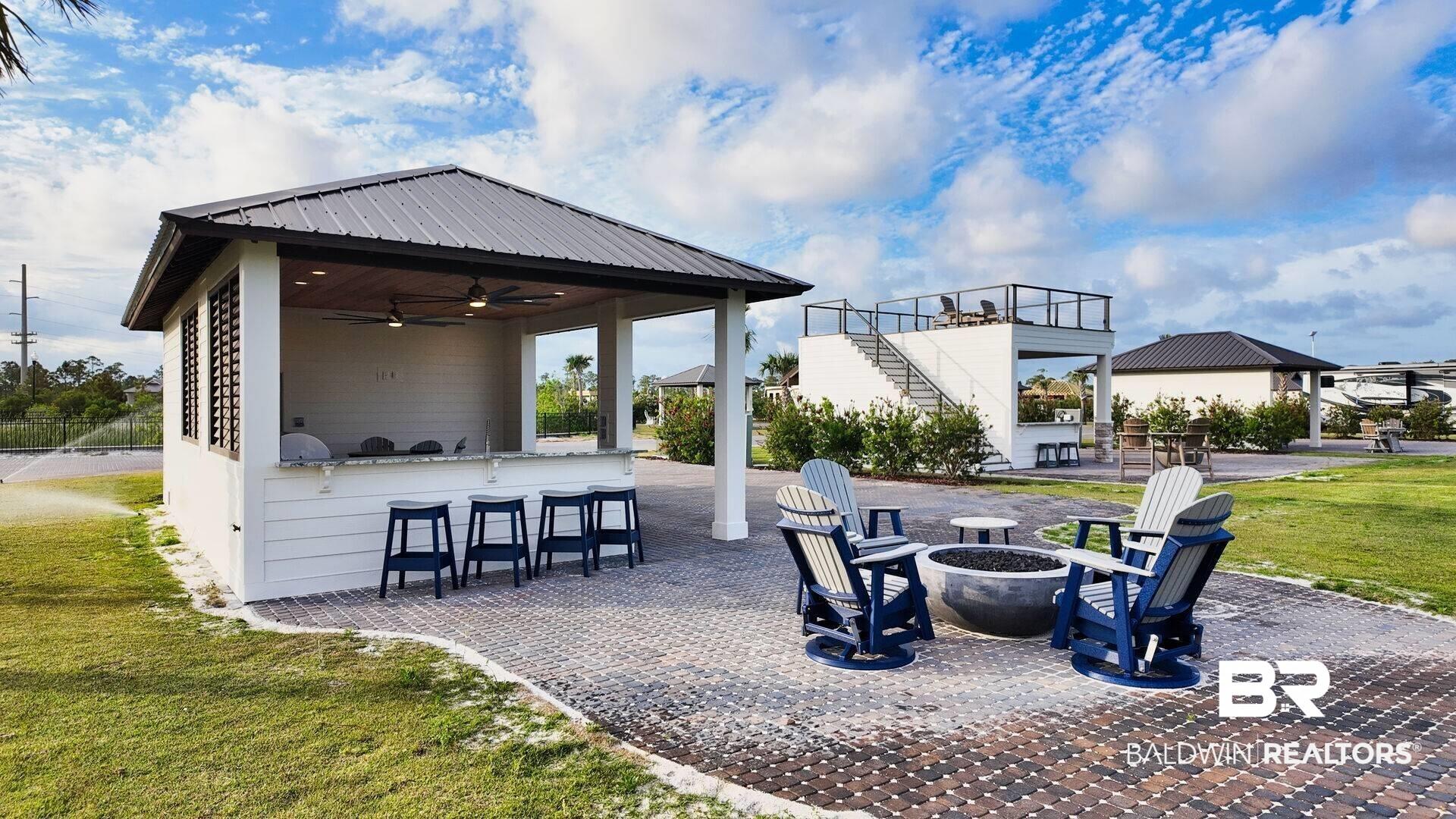 Image 2: View of patio / terrace with exterior bar, ceiling fan, stairs, and an outdoor fire pit