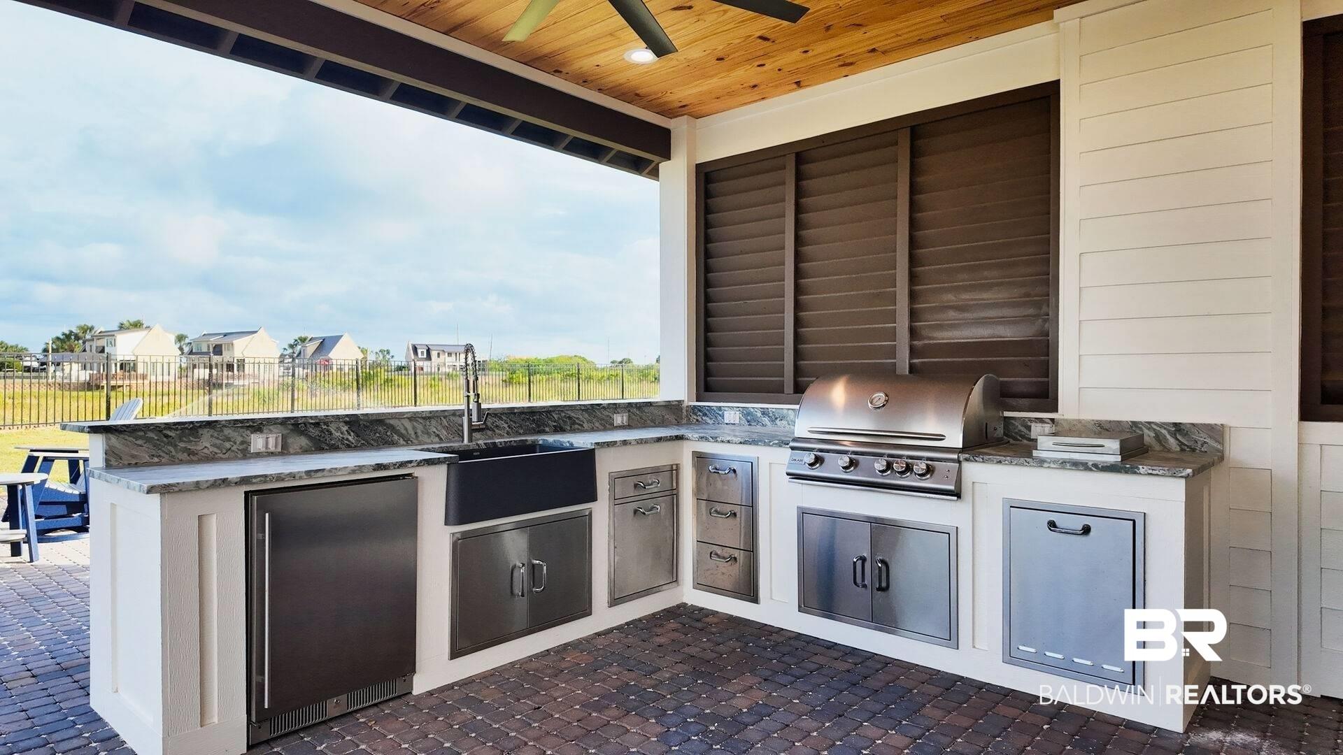 Image 4: View of patio featuring exterior kitchen, ceiling fan, and a residential view
