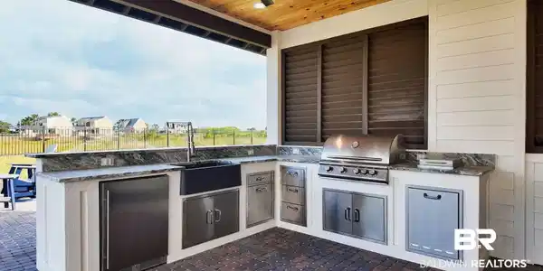 Image 4: View of patio featuring exterior kitchen, ceiling fan, and a residential view