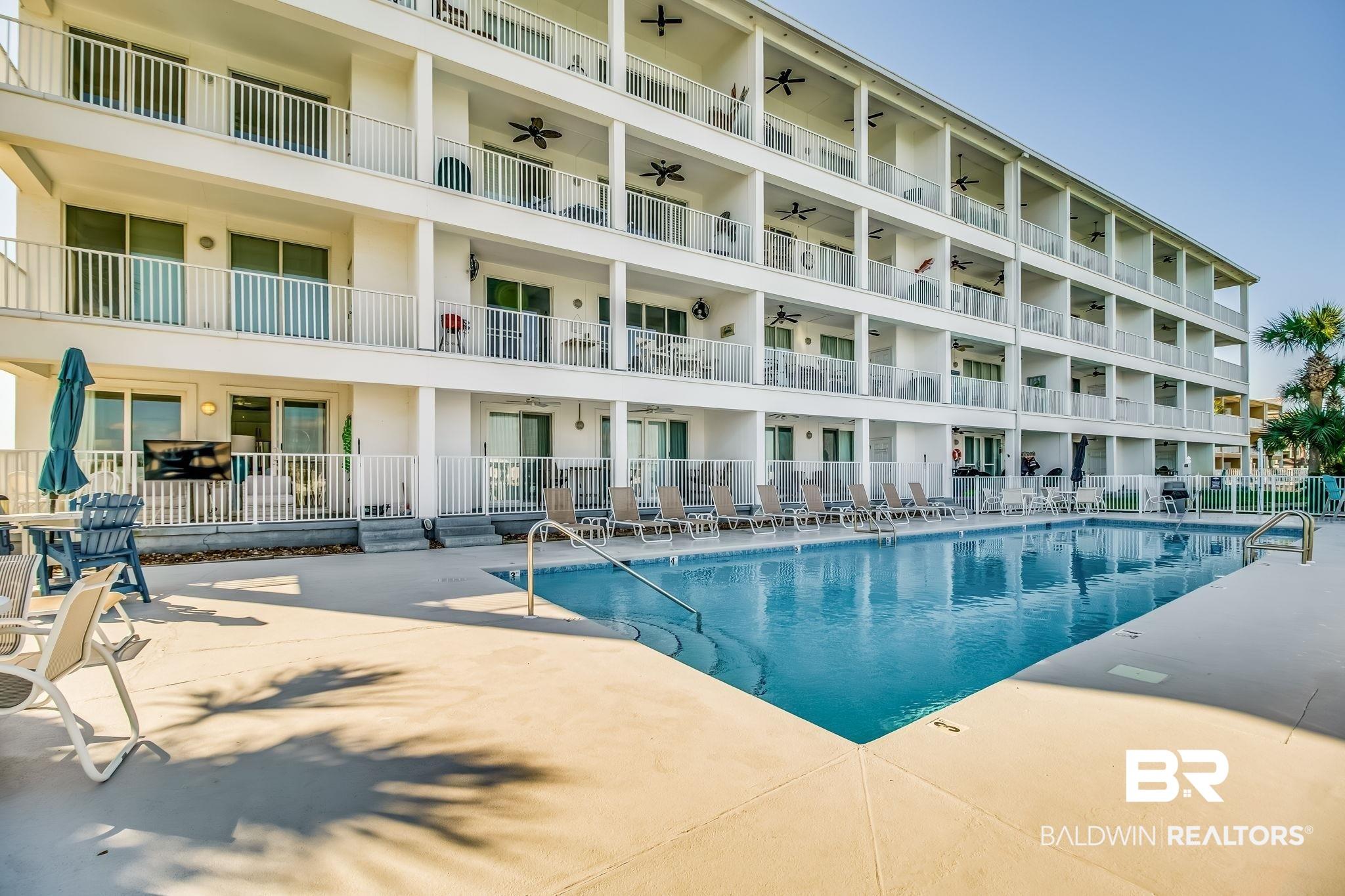 Image 1: Community pool featuring a patio area